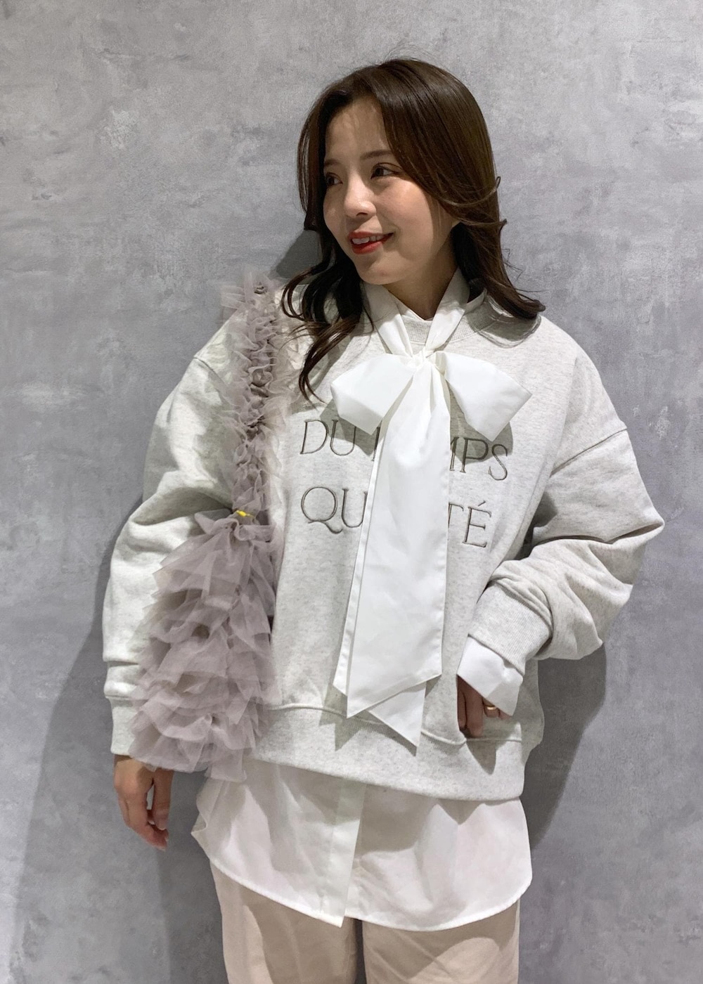 シルバー系のパンプス、ピンク系のデニムパンツ、ベージュ系のショルダーバッグを着用したレディースの冬コーディネートの7枚目の写真