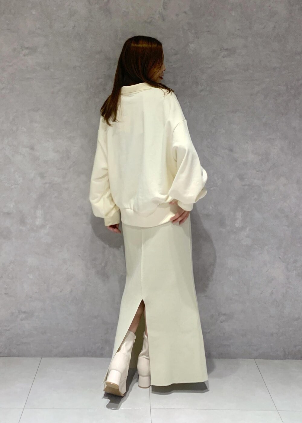 ホワイト系のブーツ、ホワイト系のスカート、ホワイト系のブルゾンを着用したレディースの秋コーディネートの9枚目の写真