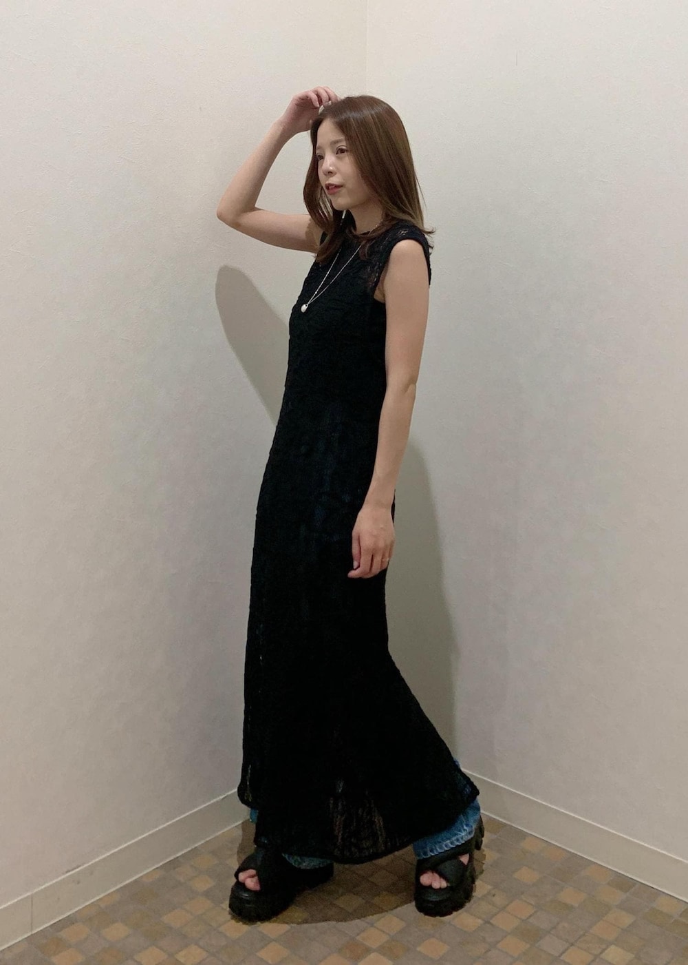 ブラック系のサンダル、グリーン系のショルダーバッグ、ブラック系のワンピースを着用したレディースの夏コーディネートの2枚目の写真