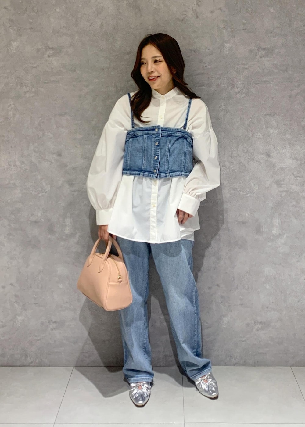 シルバー系のパンプス、ブルー系のベスト、ホワイト系のシャツ/ブラウスを着用したレディースの冬コーディネートの2枚目の写真