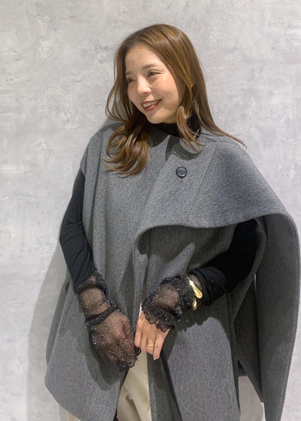 ブラック系のパンプス、グレー系のポンチョ、ブラック系のTシャツ/カットソーを着用したレディースの秋コーディネートの6枚目の写真