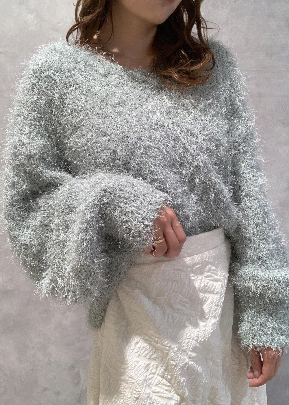 ホワイト系のブーツ、ホワイト系のスカート、グリーン系のニット/セーターを着用したレディースの冬コーディネートの7枚目の写真