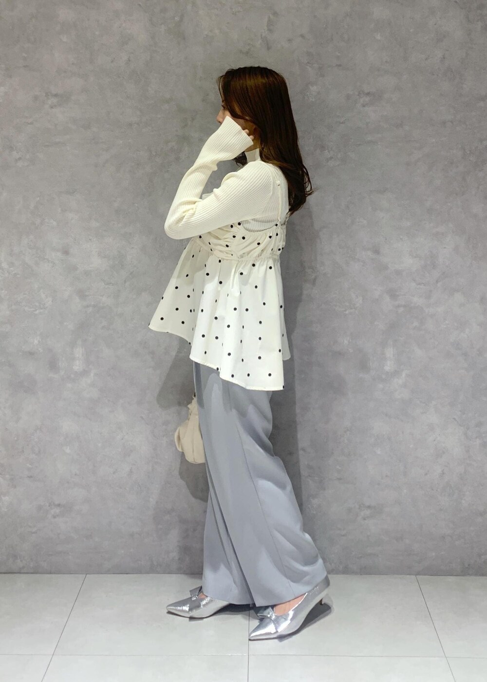 シルバー系のパンプス、ホワイト系のハンドバッグ、ホワイト系のニット/セーターを着用したレディースの冬コーディネートの4枚目の写真