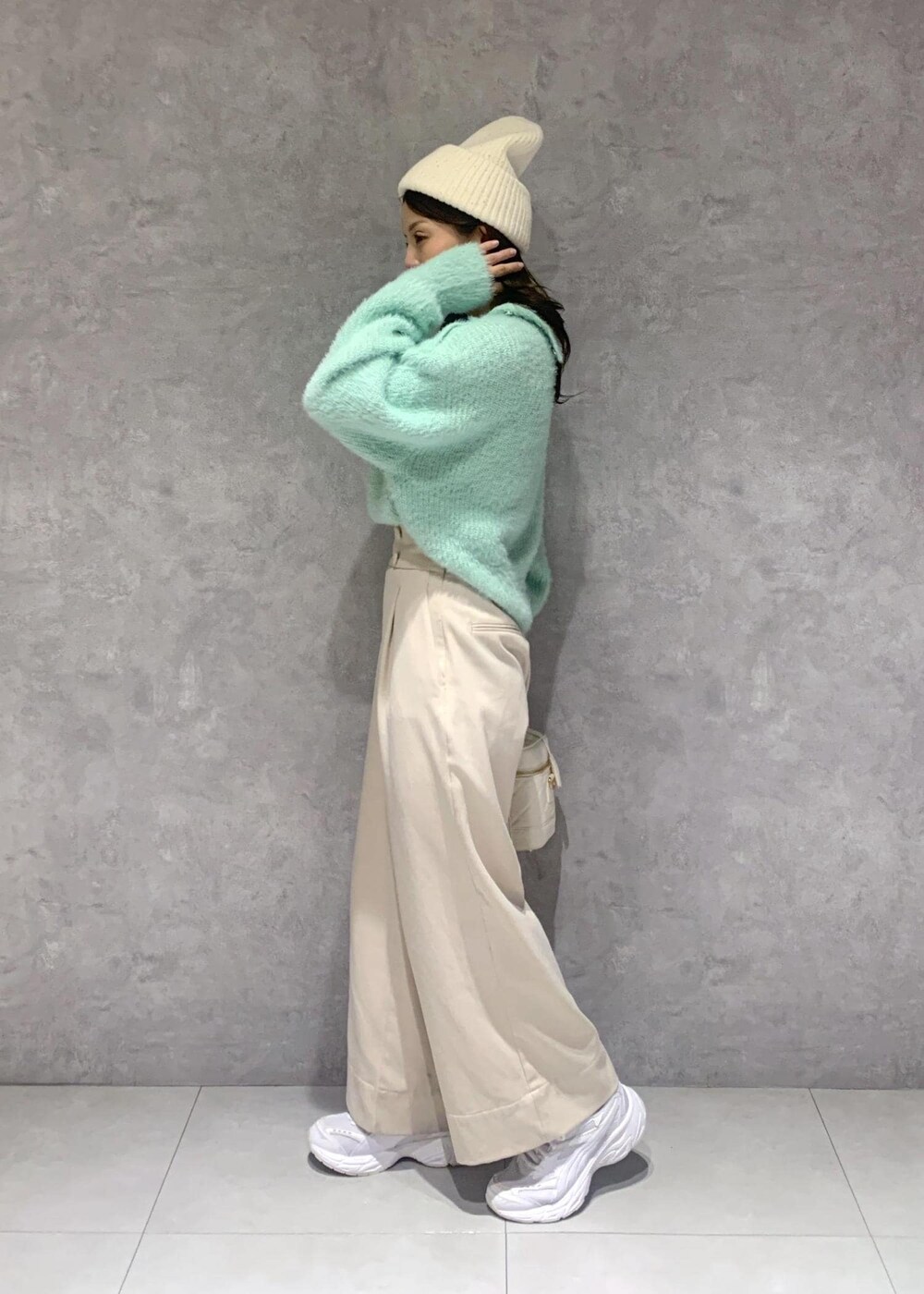 ホワイト系のハンドバッグ、ベージュ系のその他パンツ、グリーン系のニット/セーターを着用したレディースの冬コーディネートの4枚目の写真