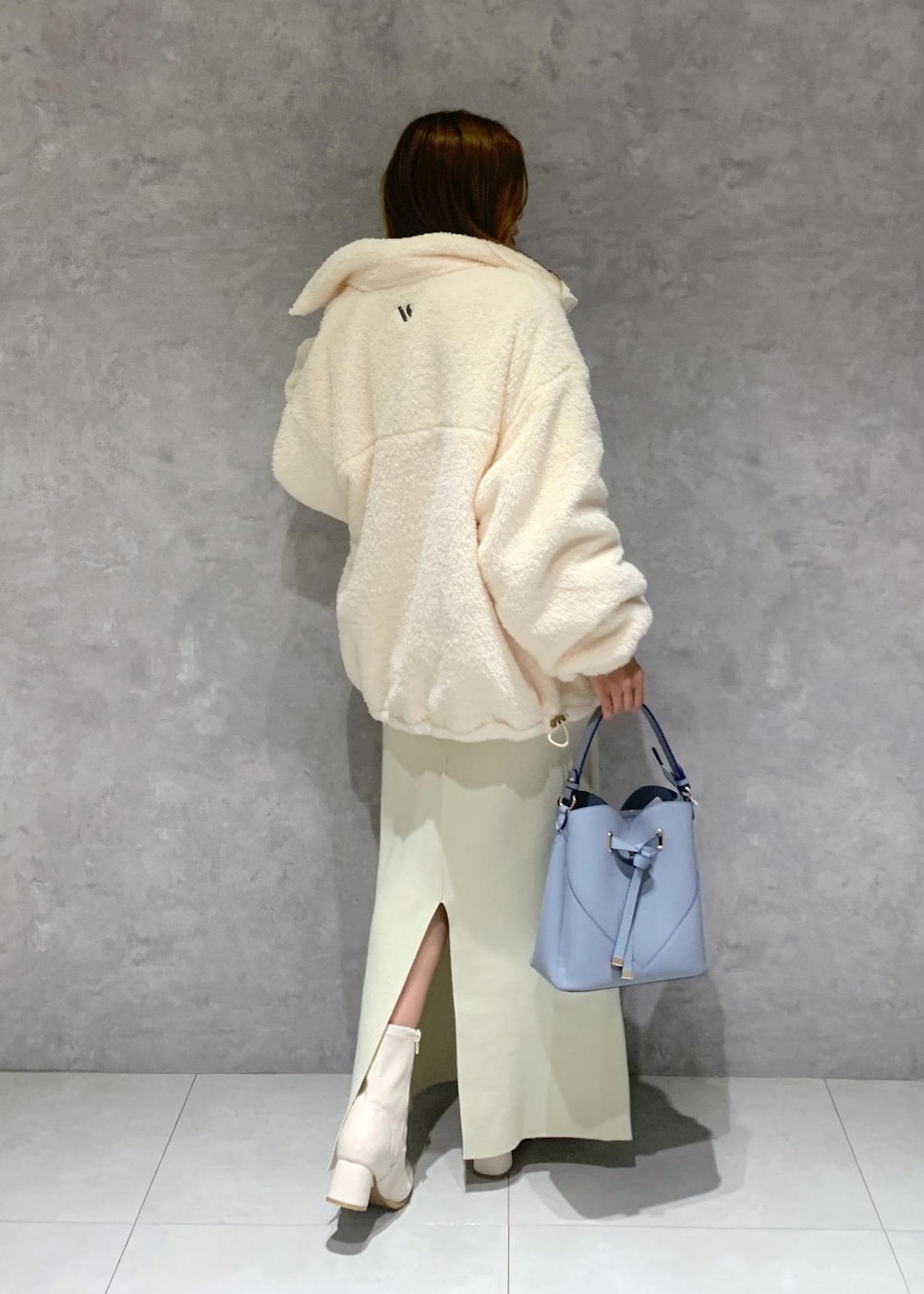 ホワイト系のブーツ、ホワイト系のスカート、ホワイト系のブルゾンを着用したレディースの秋コーディネートの5枚目の写真