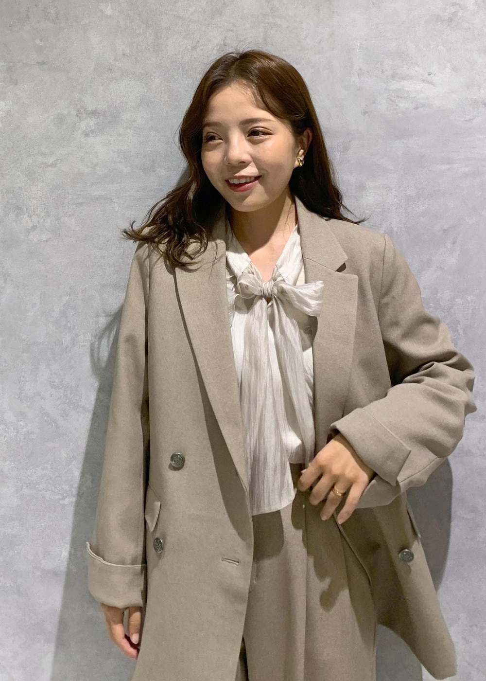 ブラウン系のブーツ、ベージュ系のショルダーバッグ、ベージュ系のスラックスを着用したレディースの秋コーディネートの5枚目の写真