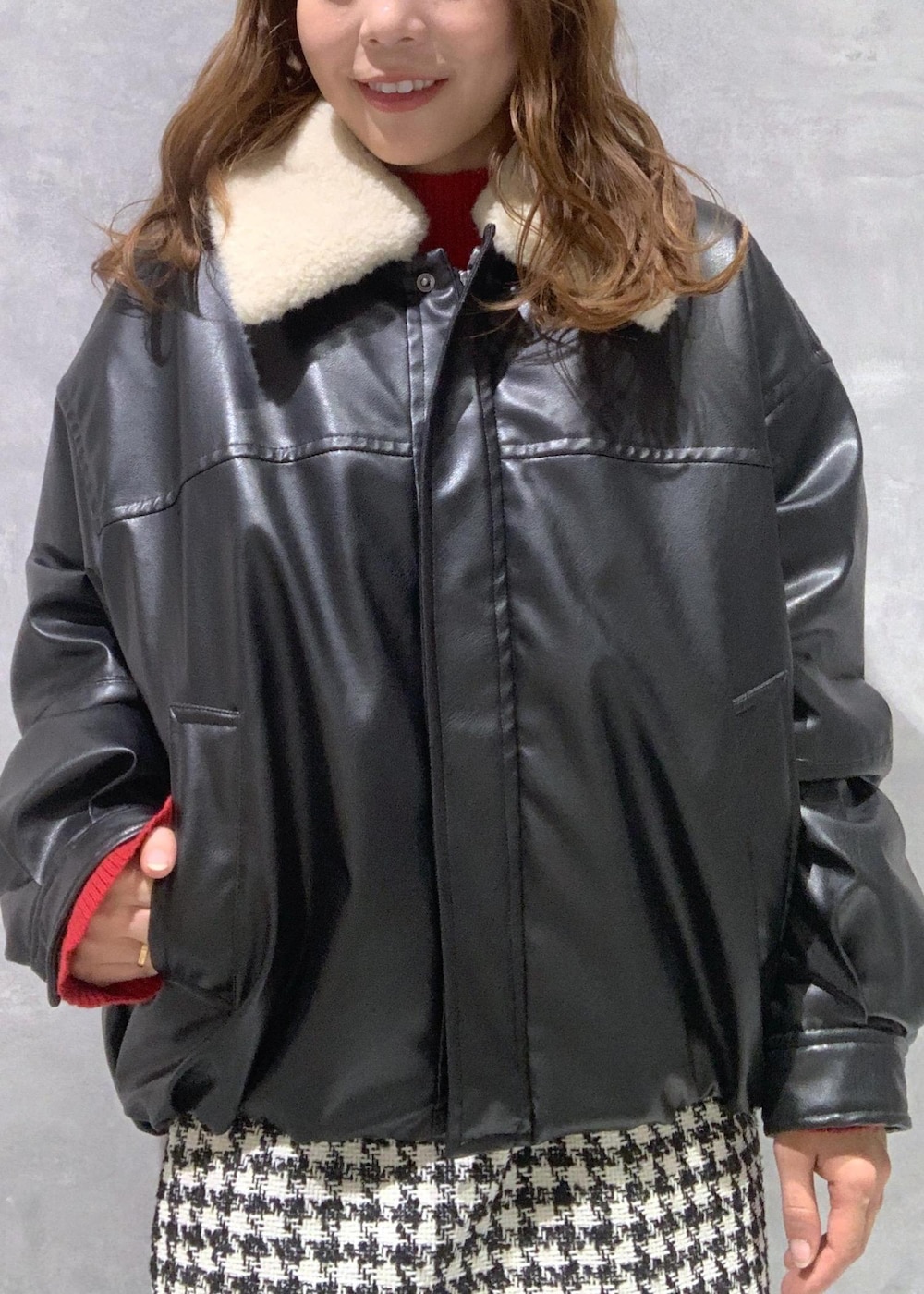 ブラック系のショルダーバッグ、ブラック系のブーツ、レッド系のニット/セーターを着用したレディースの冬コーディネートの10枚目の写真