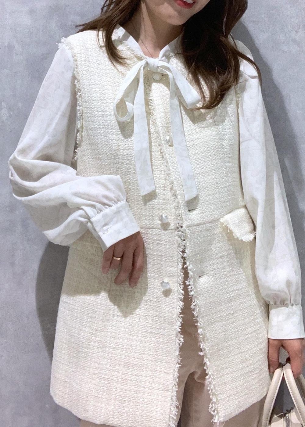 ピンク系のデニムパンツ、ホワイト系のシャツ/ブラウス、ホワイト系のベストを着用したレディースの冬コーディネートの7枚目の写真