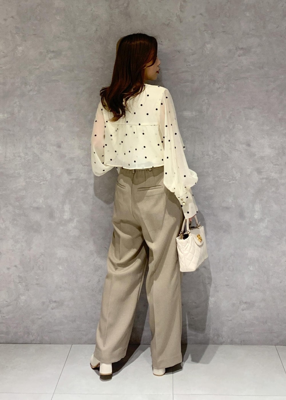 ホワイト系のブーツ、ベージュ系のシャツ/ブラウス、ベージュ系のスラックスを着用したレディースの冬コーディネートの8枚目の写真