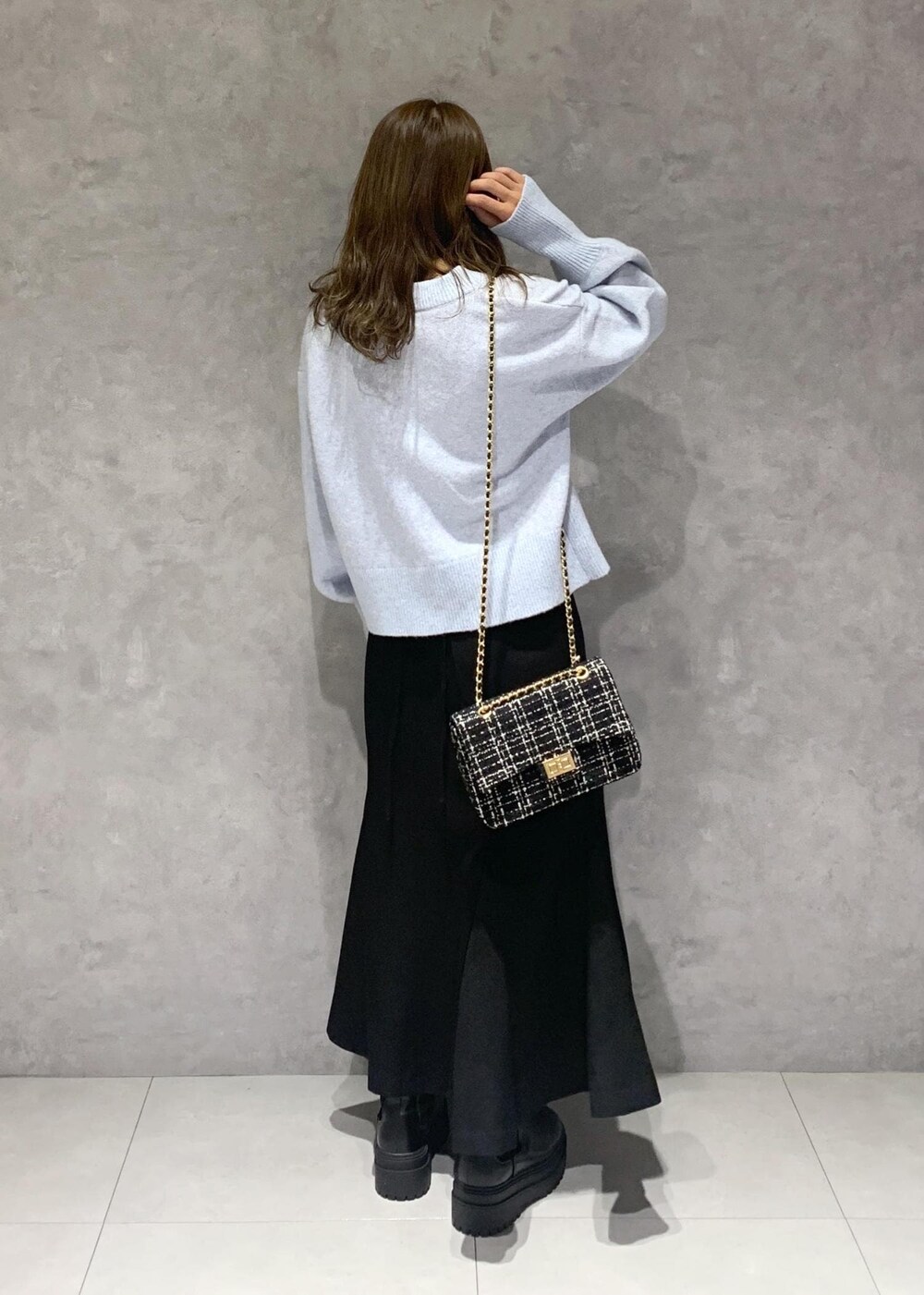 ブラック系のブーツ、ブラック系のショルダーバッグ、ブラック系のスカートを着用したレディースの秋コーディネートの4枚目の写真