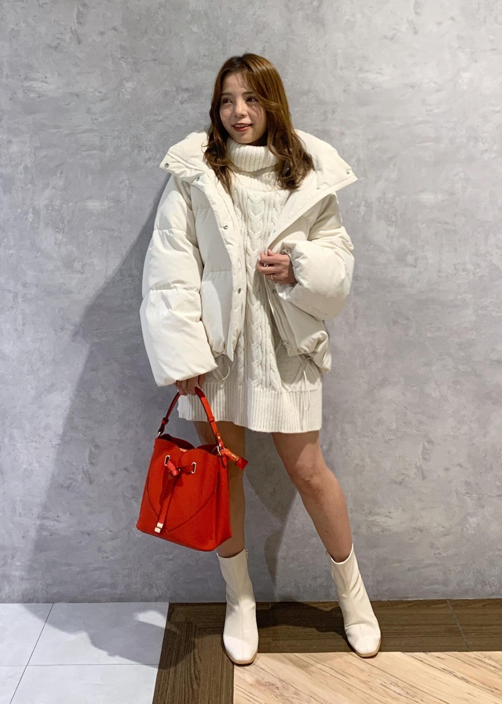 ホワイト系のブーツ、ホワイト系のワンピース、ホワイト系のダウンジャケット/コートを着用したレディースの秋コーディネートの2枚目の写真