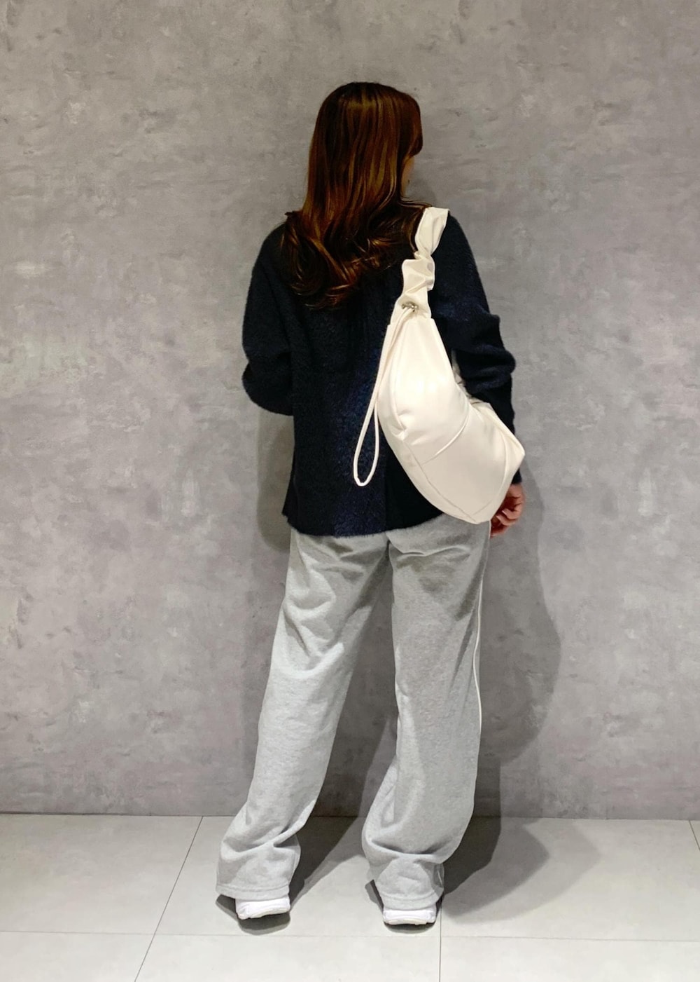 ブラック系のキャミソール、グレー系のその他パンツ、ホワイト系のショルダーバッグを着用したレディースの冬コーディネートの5枚目の写真