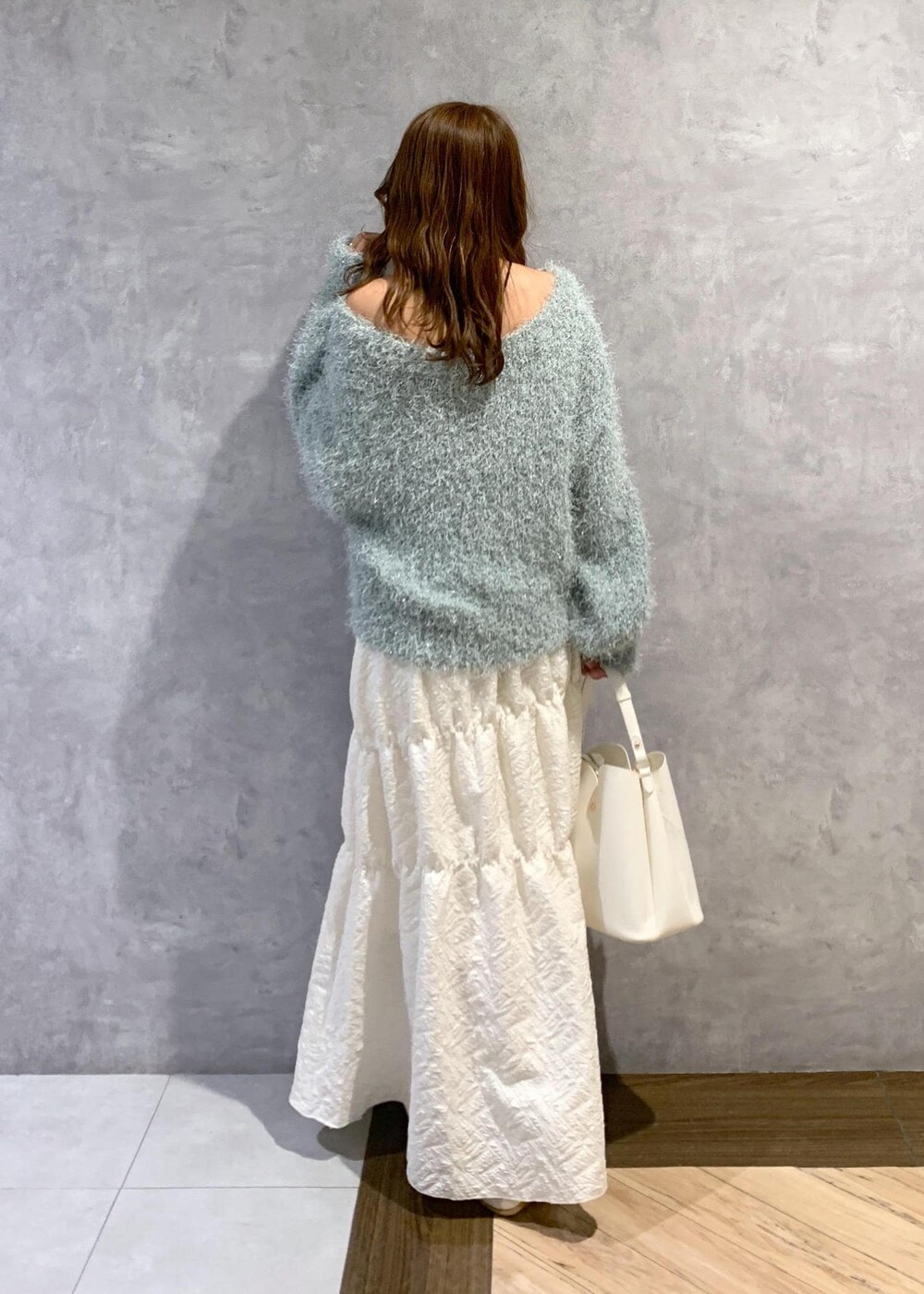 ホワイト系のブーツ、ホワイト系のスカート、グリーン系のニット/セーターを着用したレディースの冬コーディネートの4枚目の写真