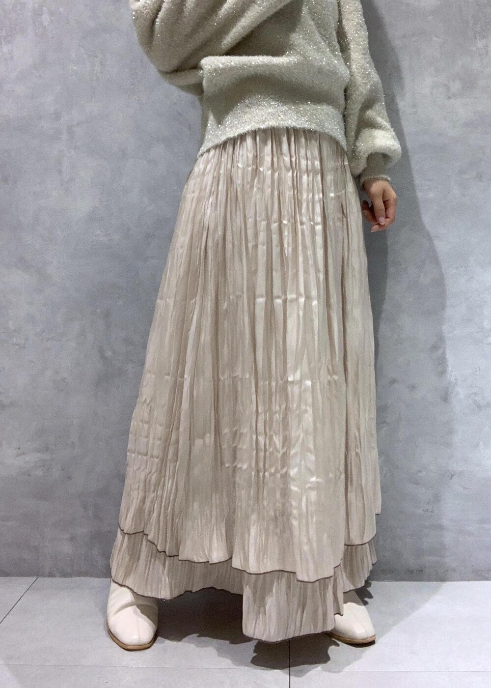 ピンク系のショルダーバッグ、ホワイト系のブーツ、ベージュ系のスカートを着用したレディースの冬コーディネートの10枚目の写真