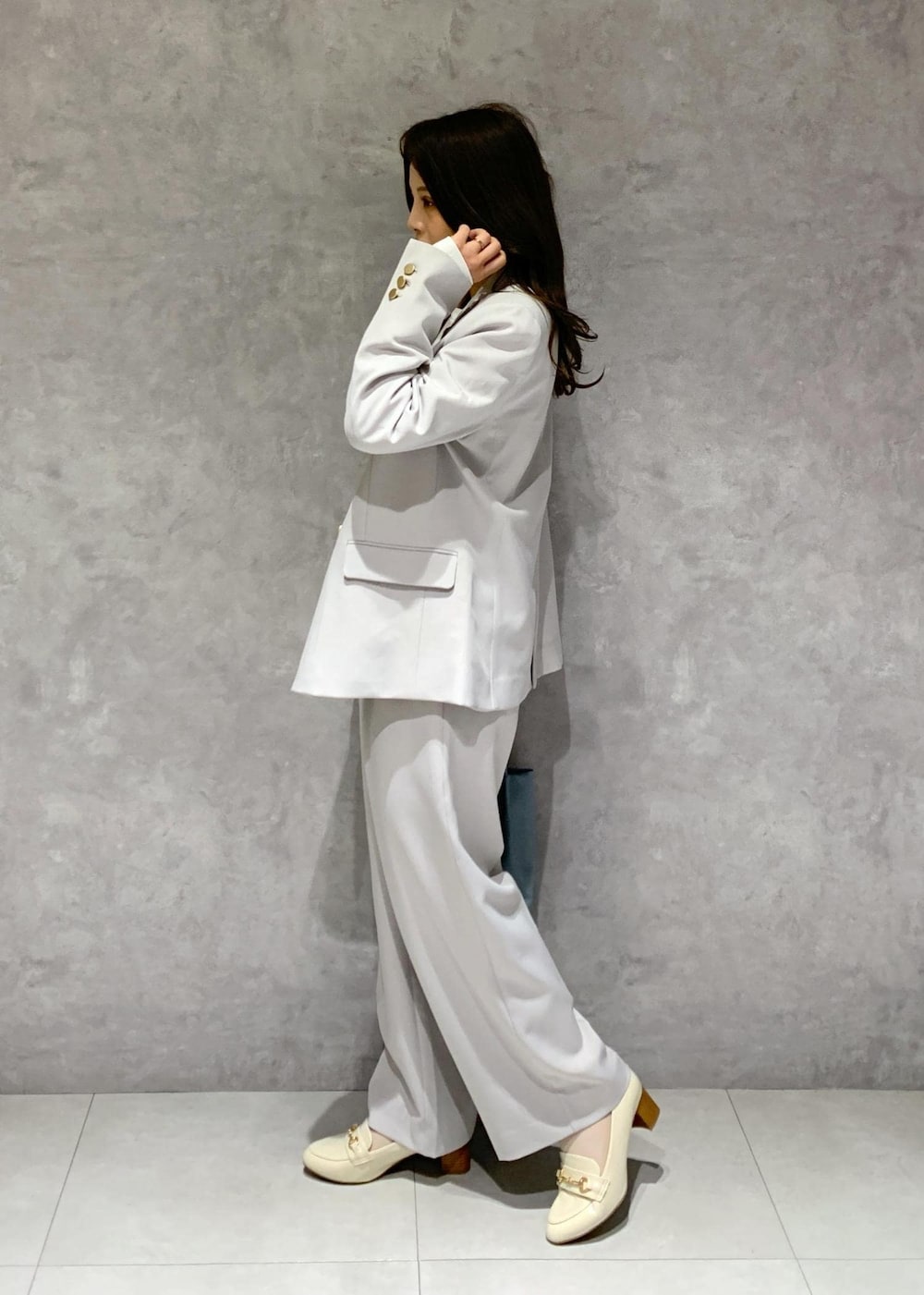 ブルー系のトートバッグ、ホワイト系のTシャツ/カットソー、ホワイト系のローファーを着用したレディースの冬コーディネートの4枚目の写真