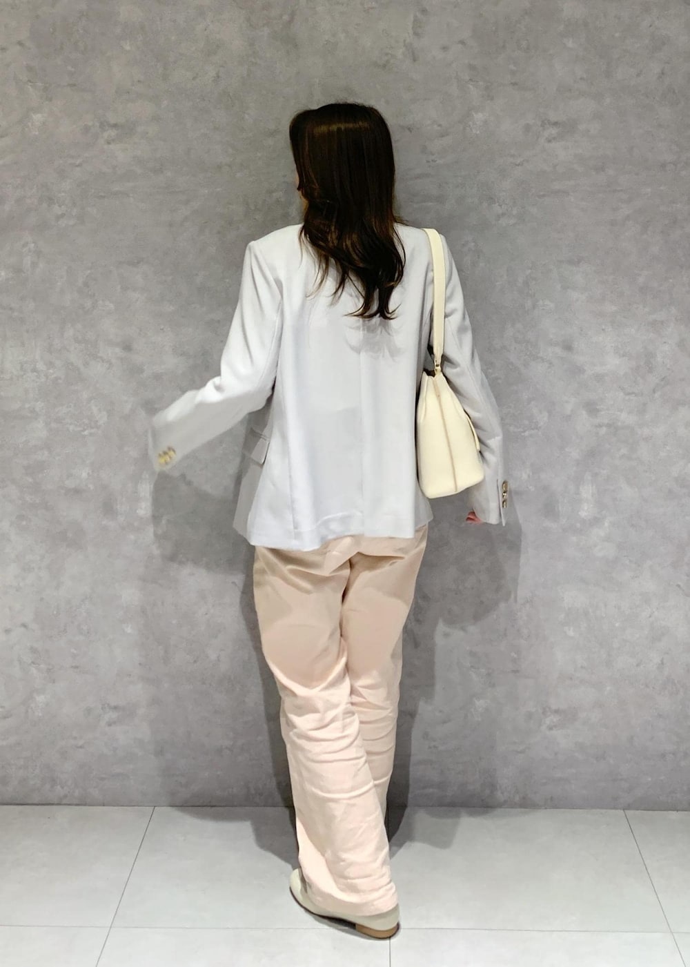 ホワイト系のハンドバッグ、ピンク系のデニムパンツ、ホワイト系のニット/セーターを着用したレディースの冬コーディネートの5枚目の写真