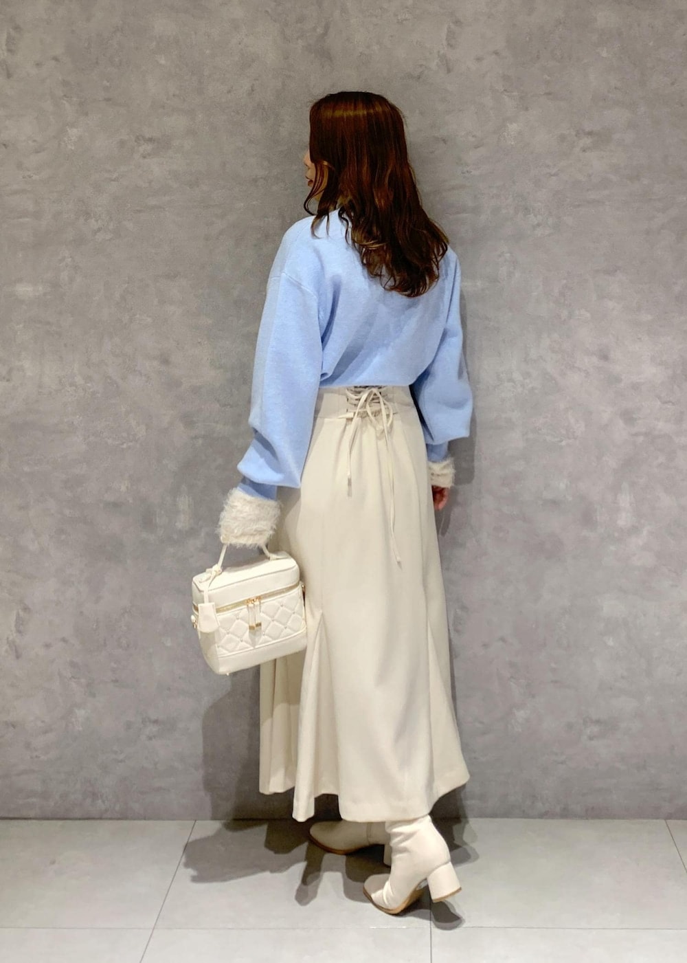 ホワイト系のニット/セーター、ホワイト系のブーツ、ホワイト系のハンドバッグを着用したレディースの冬コーディネートの5枚目の写真