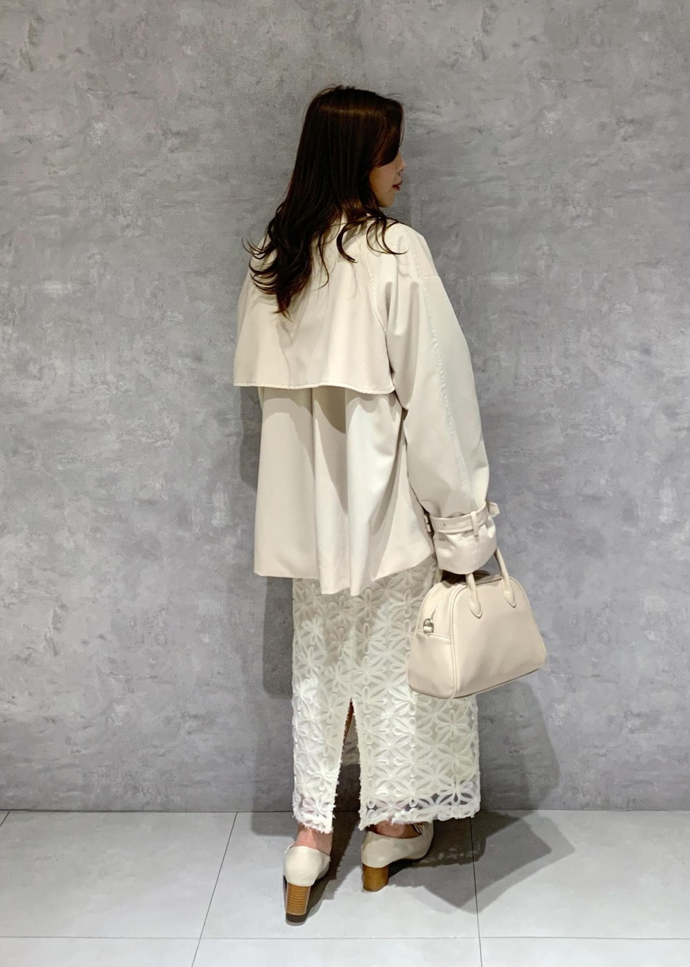 ホワイト系のスカート、ベージュ系のトレンチコート、ベージュ系のニット/セーターを着用したレディースの冬コーディネートの6枚目の写真