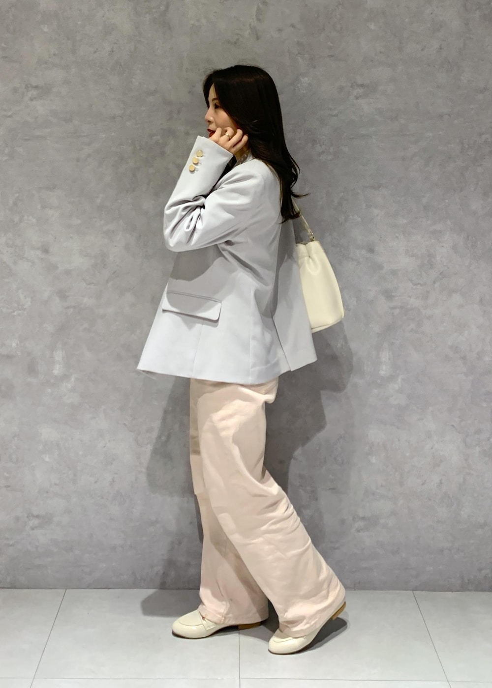 ホワイト系のハンドバッグ、ピンク系のデニムパンツ、ホワイト系のニット/セーターを着用したレディースの冬コーディネートの4枚目の写真