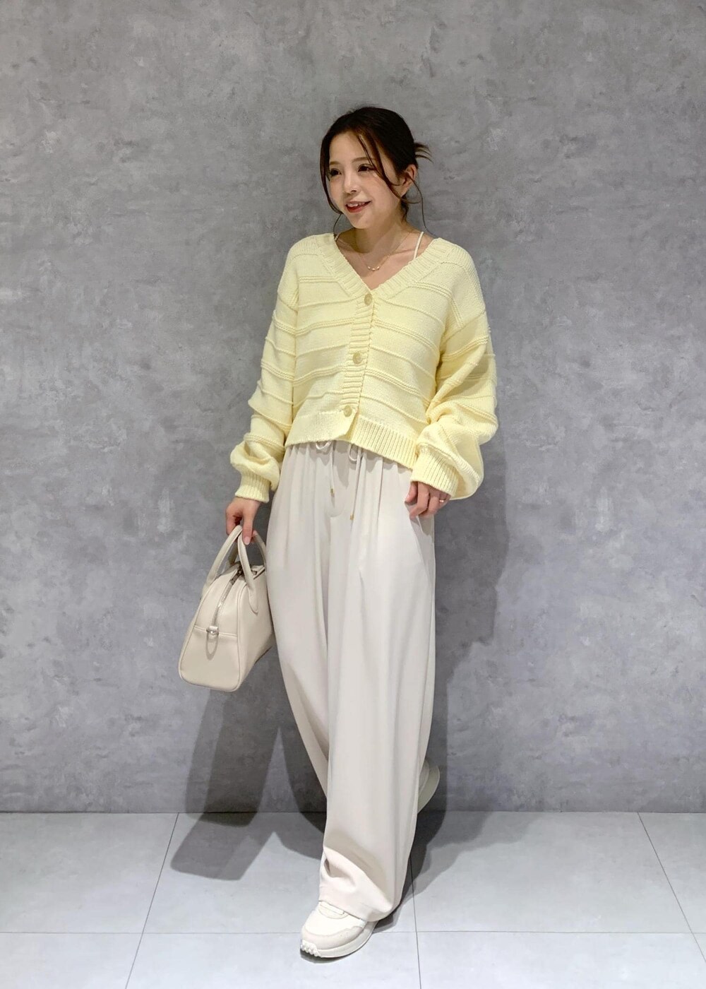 ベージュ系のボストンバッグ、ベージュ系のカーディガン/ボレロ、ベージュ系のその他パンツを着用したレディースの春コーディネートの3枚目の写真