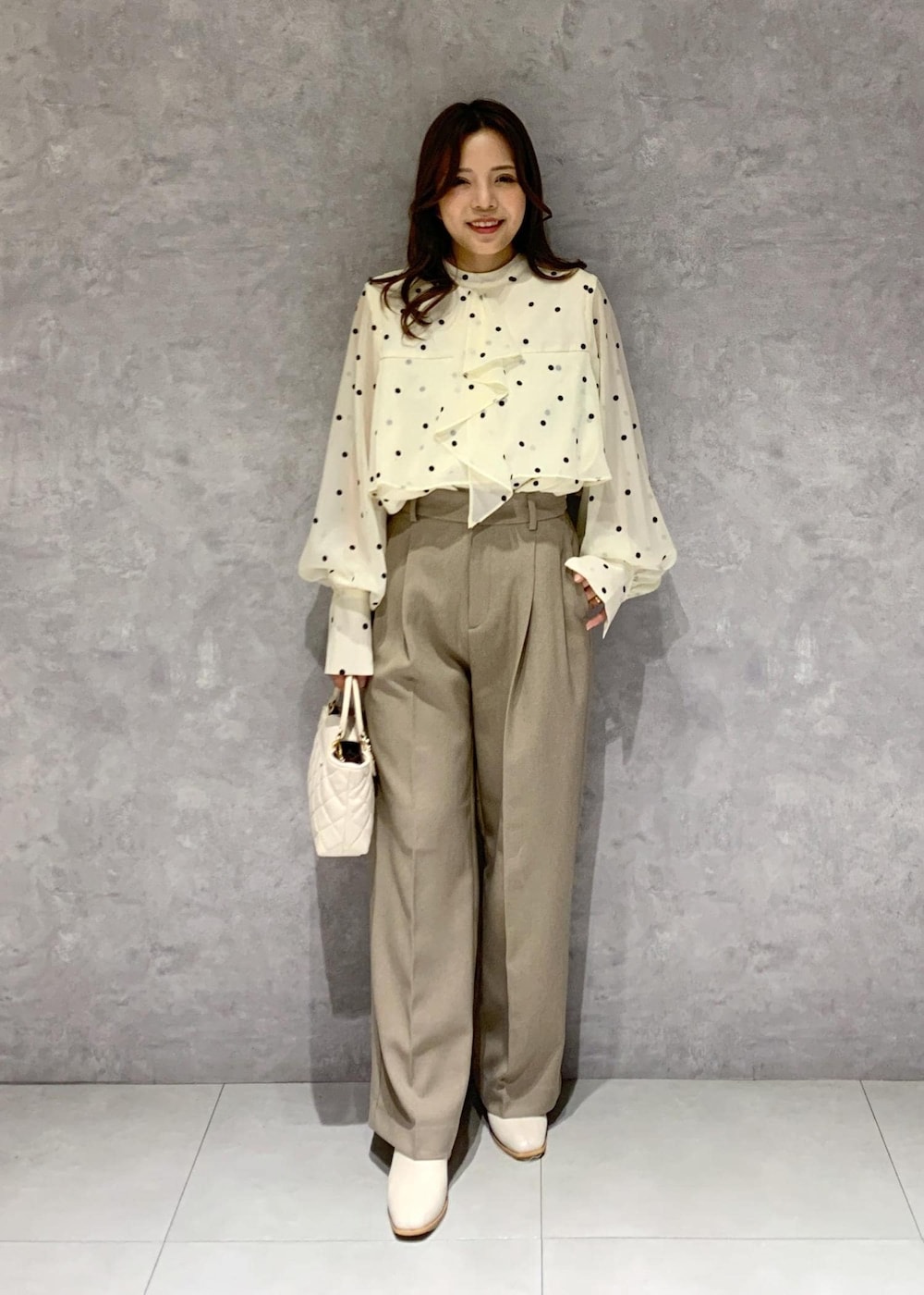 ホワイト系のブーツ、ベージュ系のシャツ/ブラウス、ベージュ系のスラックスを着用したレディースの冬コーディネートの6枚目の写真