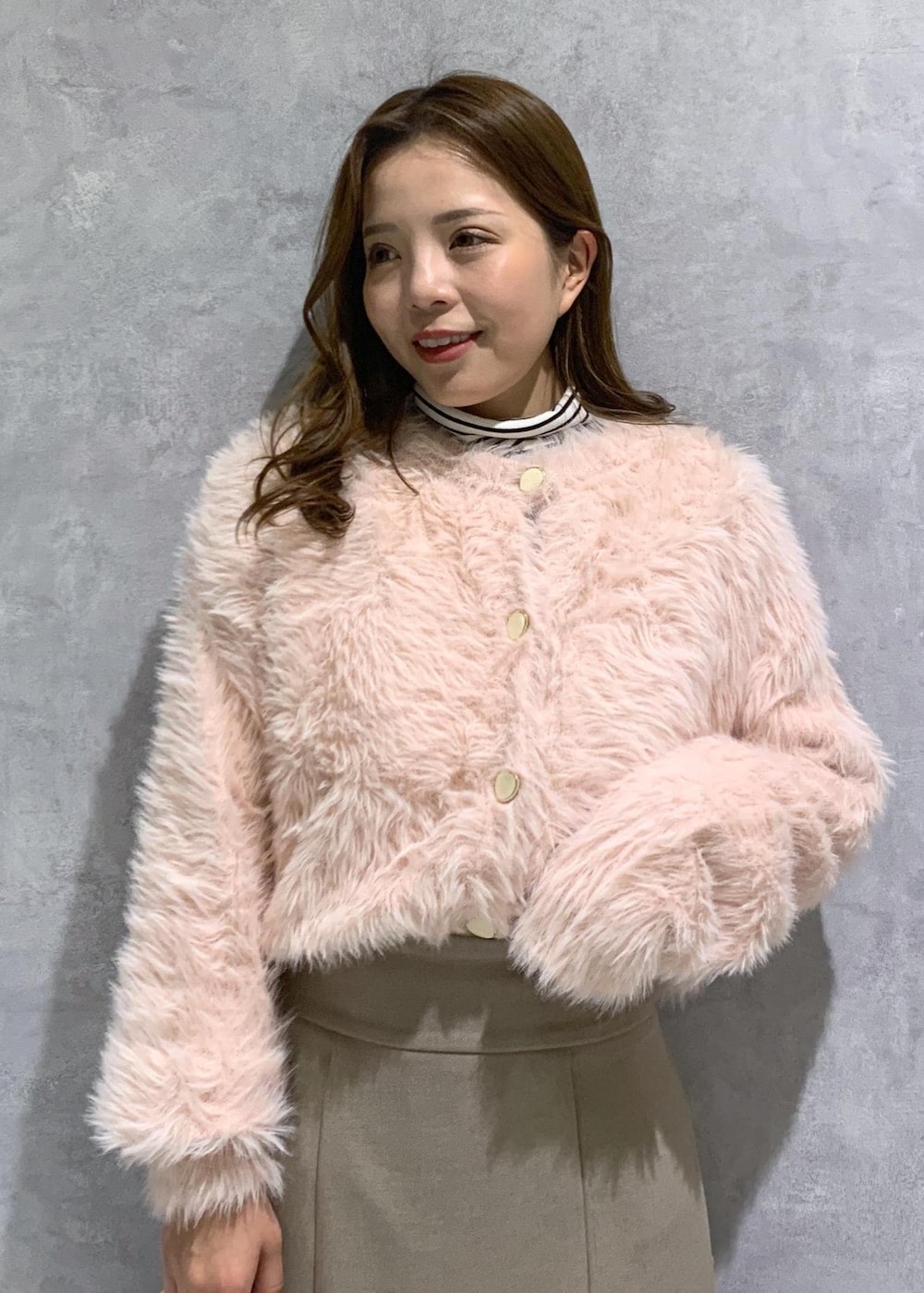 ホワイト系のブーツ、ベージュ系のスカート、ピンク系のカーディガン/ボレロを着用したレディースの冬コーディネートの7枚目の写真