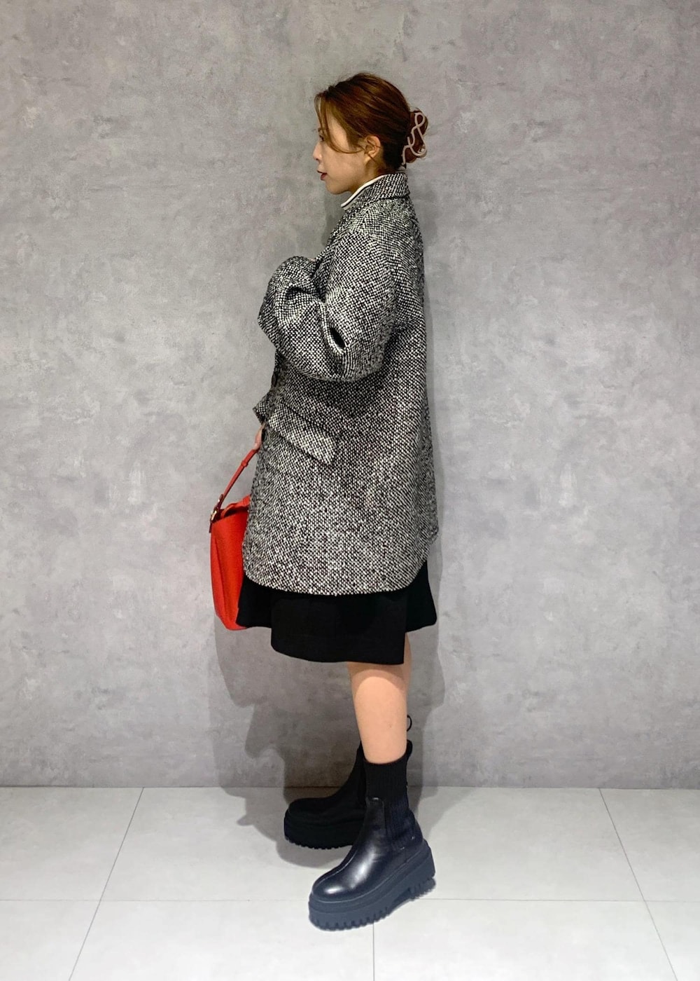 ブラック系のブーツ、レッド系のショルダーバッグ、ブラック系のワンピースを着用したレディースの冬コーディネートの3枚目の写真