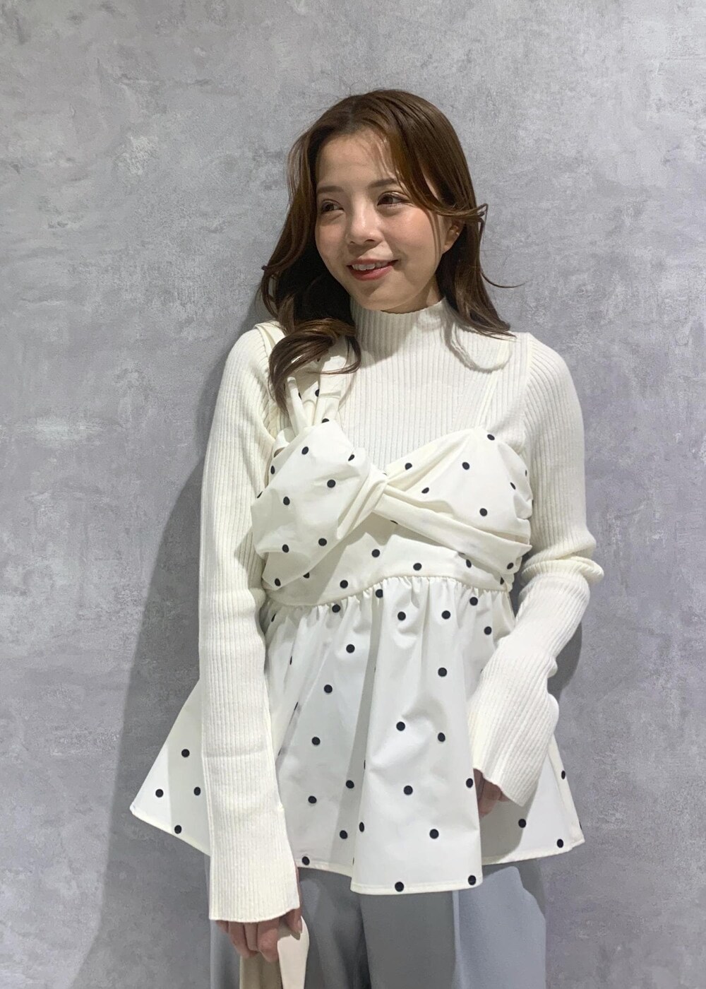 シルバー系のパンプス、ホワイト系のハンドバッグ、ホワイト系のニット/セーターを着用したレディースの冬コーディネートの7枚目の写真