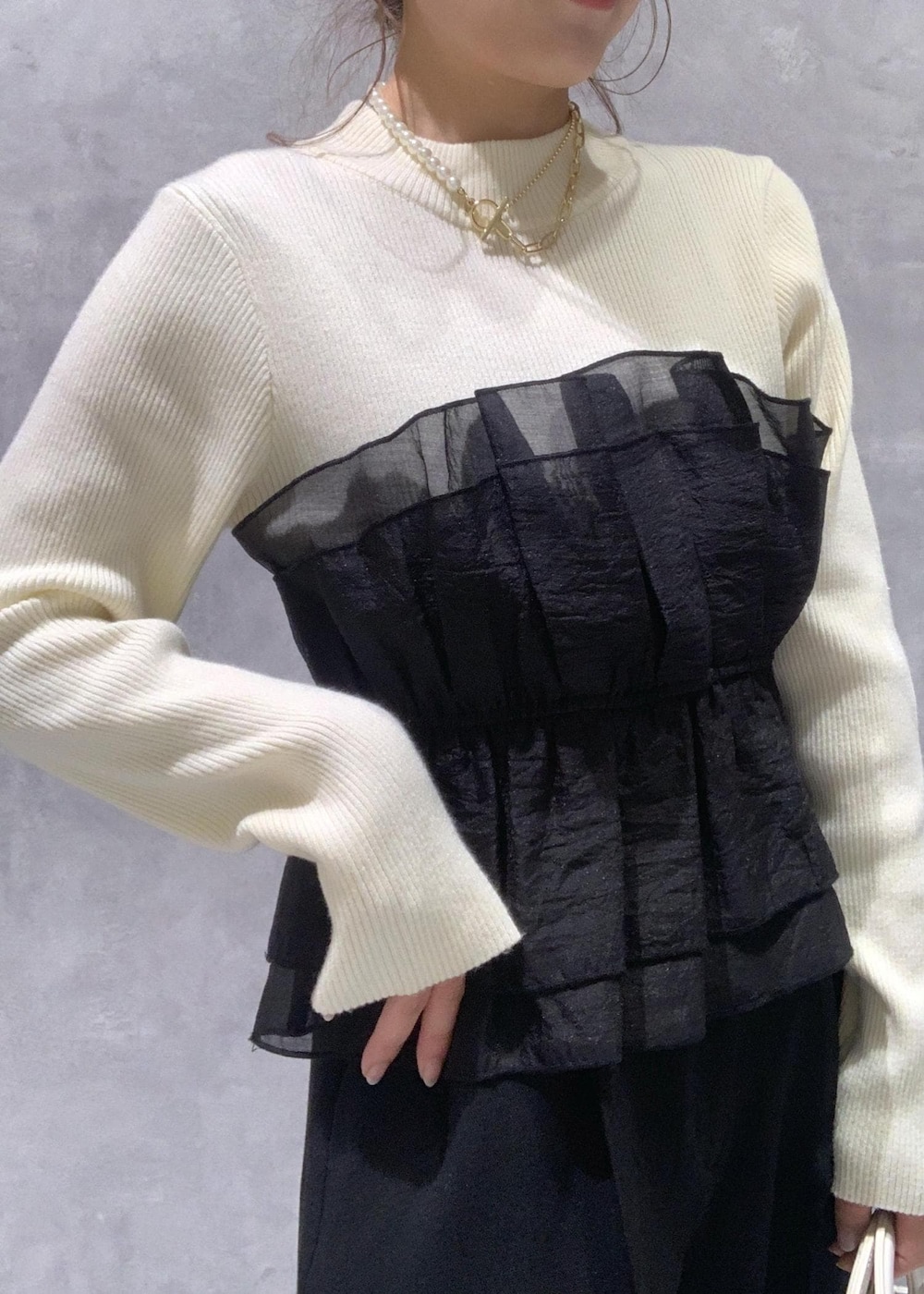 ブラック系のパンプス、ホワイト系のニット/セーター、ブラック系のスラックスを着用したレディースの冬コーディネートの8枚目の写真