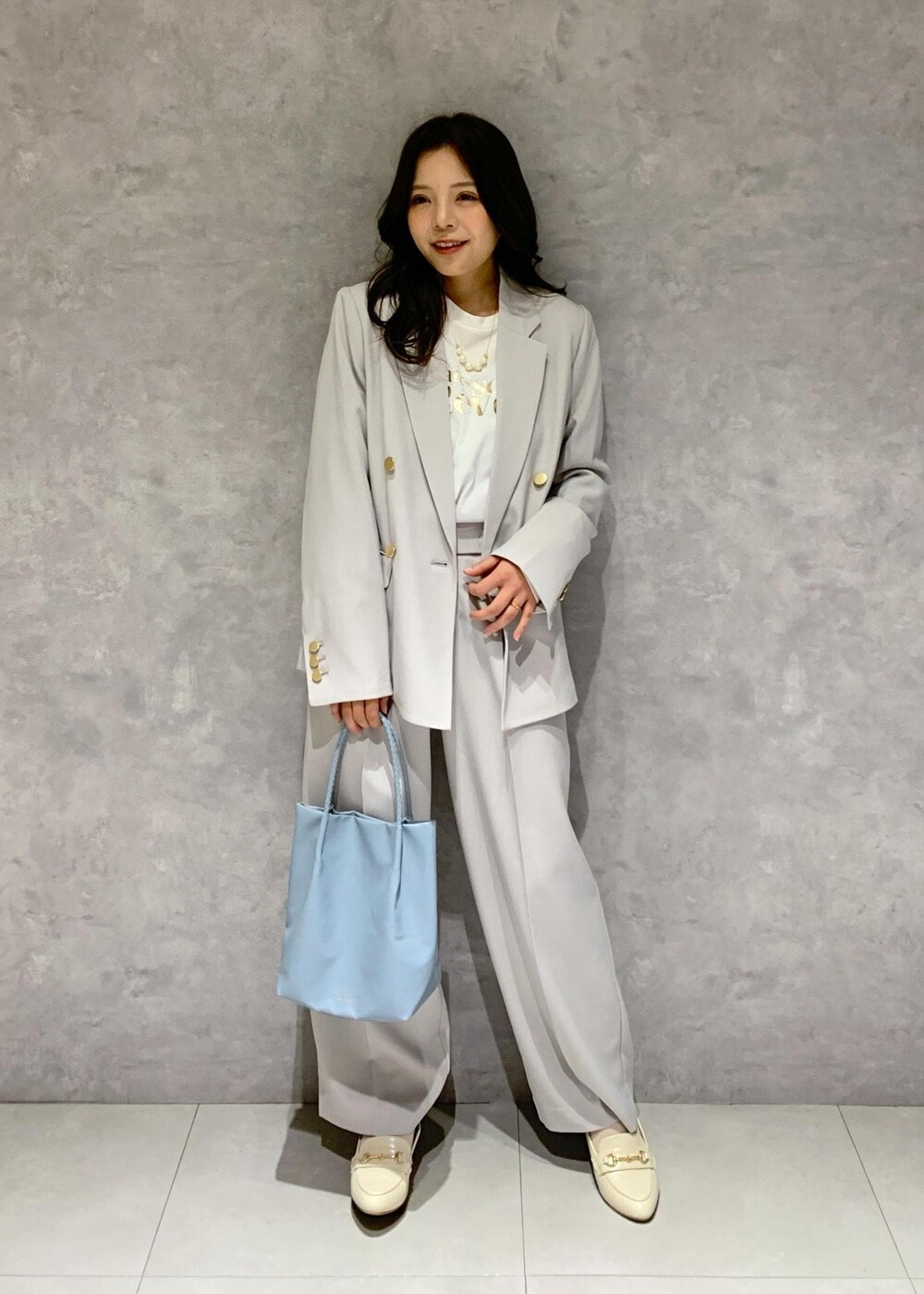 ブルー系のトートバッグ、ホワイト系のTシャツ/カットソー、ホワイト系のローファーを着用したレディースの冬コーディネートの2枚目の写真