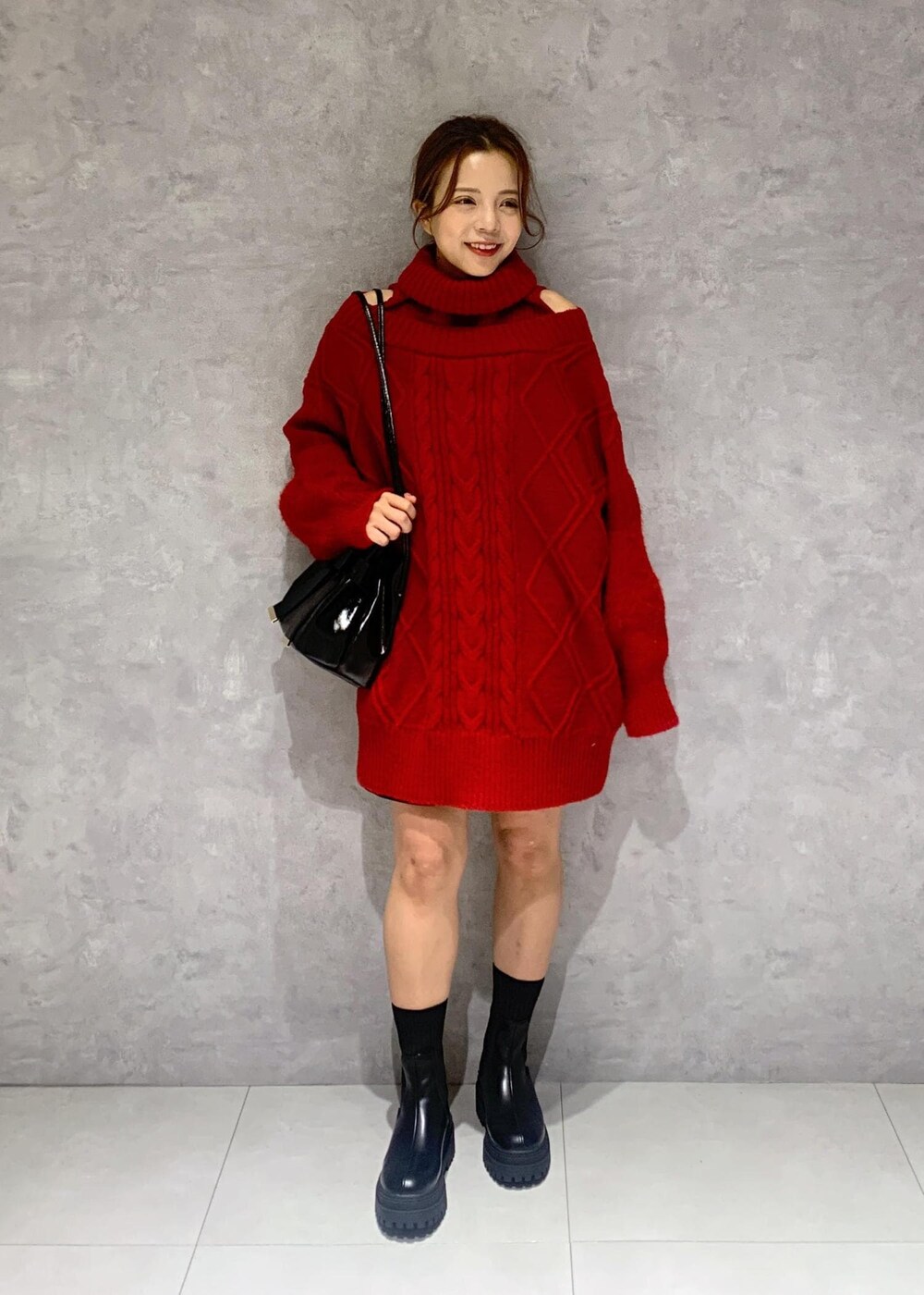 ブラック系のショルダーバッグ、ブラック系のブーツ、レッド系のワンピースを着用したレディースの冬コーディネートの7枚目の写真