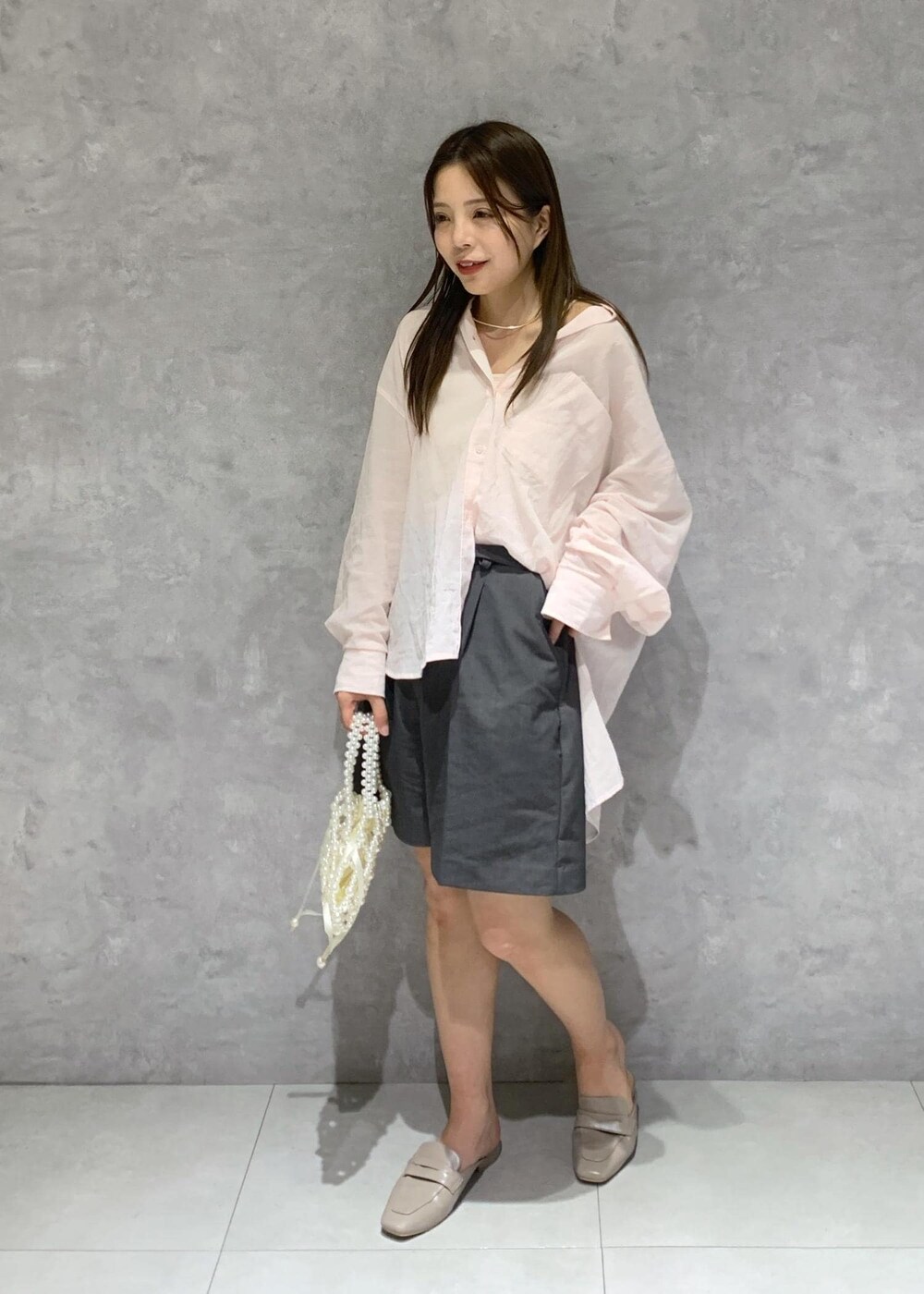 ピンク系のシャツ/ブラウス、グレー系のローファー、ホワイト系のハンドバッグを着用したレディースの春コーディネートの3枚目の写真