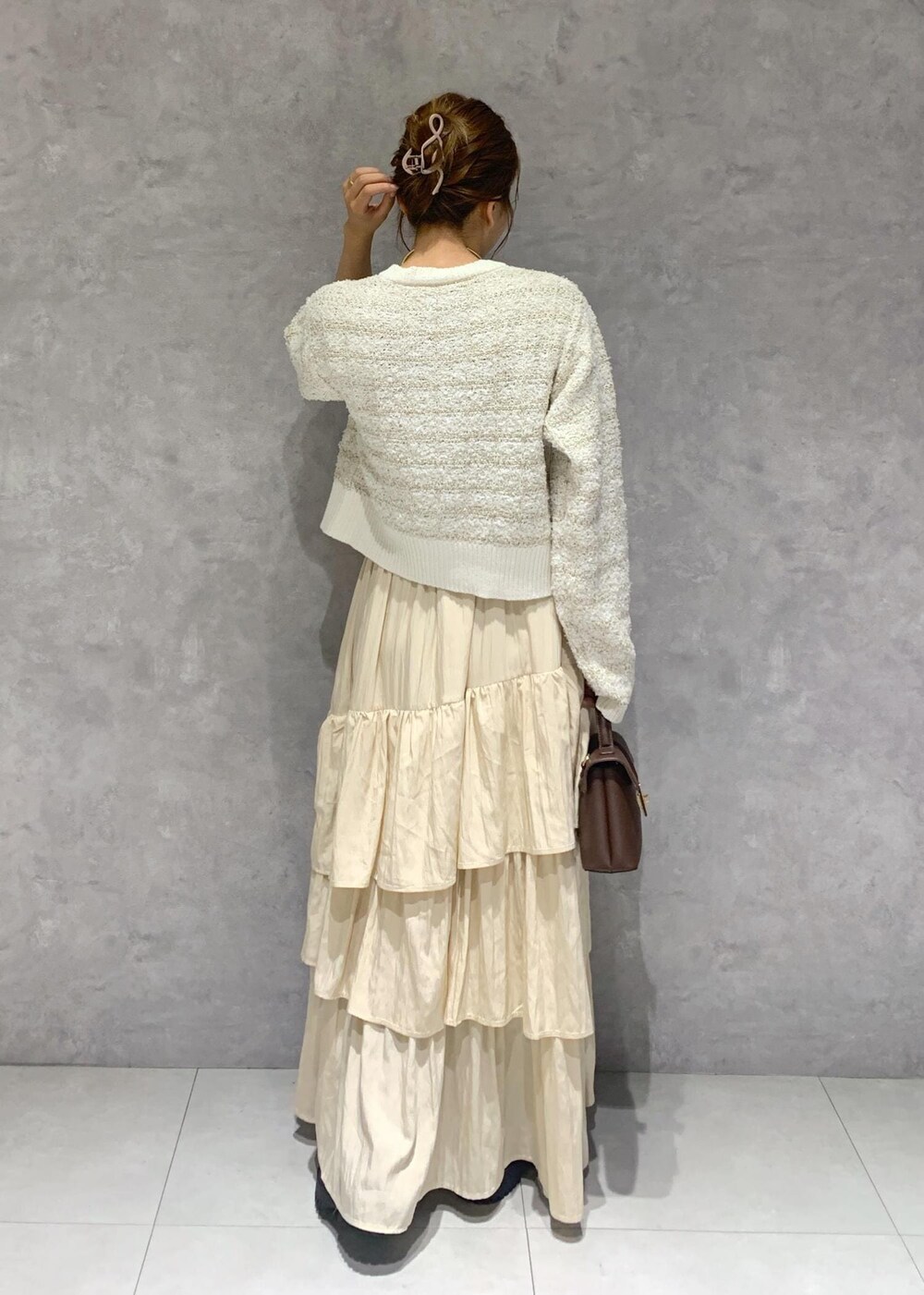 ブラウン系のショルダーバッグ、ブラウン系のブーツ、ホワイト系のカーディガン/ボレロを着用したレディースの夏コーディネートの6枚目の写真