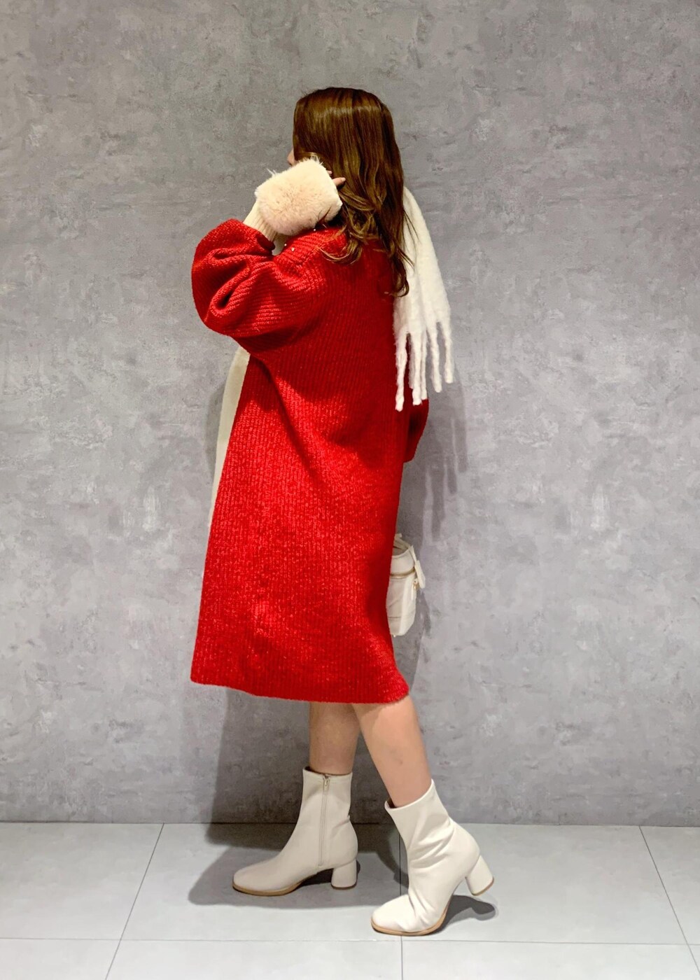 ホワイト系のブーツ、ホワイト系のハンドバッグ、レッド系のワンピースを着用したレディースの冬コーディネートの4枚目の写真