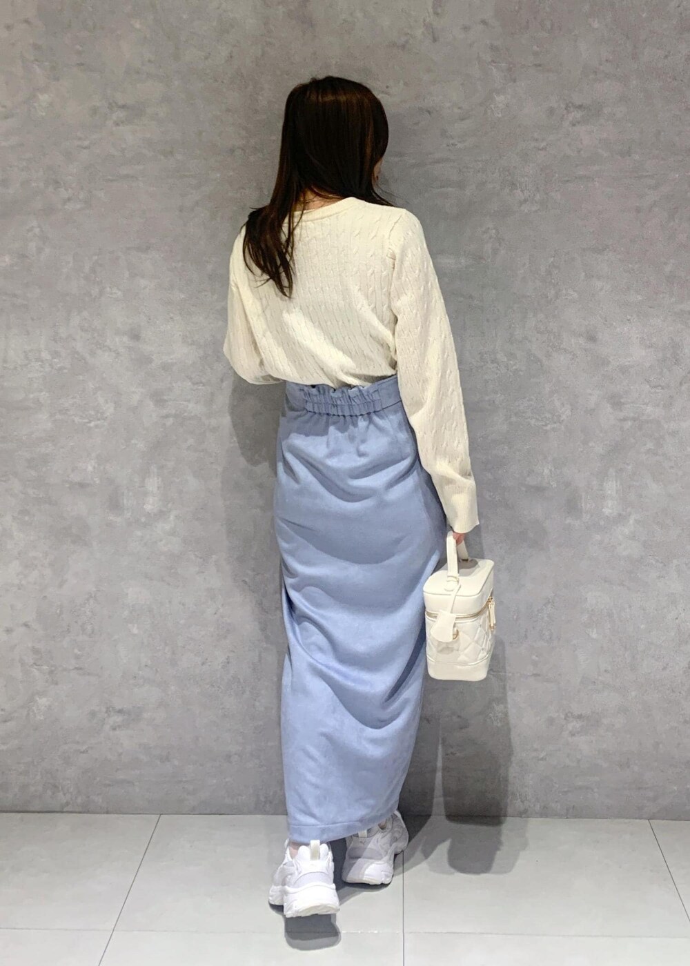 ホワイト系のハンドバッグ、ホワイト系のカーディガン/ボレロ、ブルー系のスカートを着用したレディースの冬コーディネートの5枚目の写真