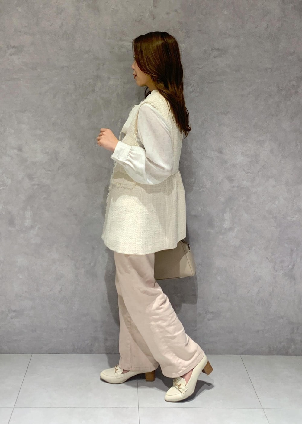 ピンク系のデニムパンツ、ホワイト系のシャツ/ブラウス、ホワイト系のベストを着用したレディースの冬コーディネートの4枚目の写真