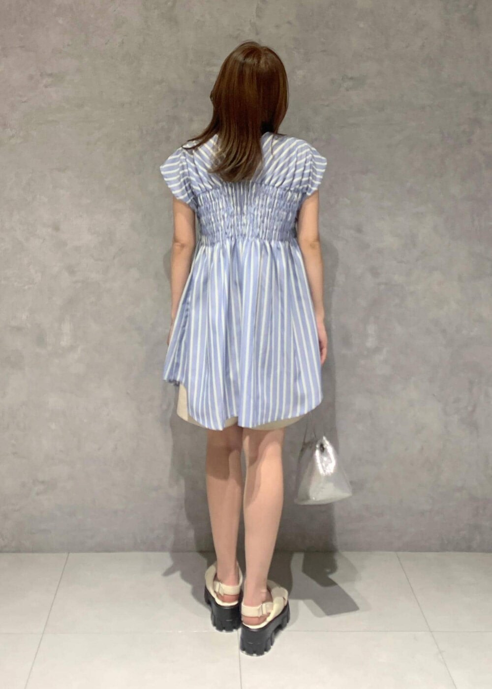 ホワイト系のサンダル、シルバー系のショルダーバッグ、ブルー系のシャツ/ブラウスを着用したレディースの夏コーディネートの4枚目の写真