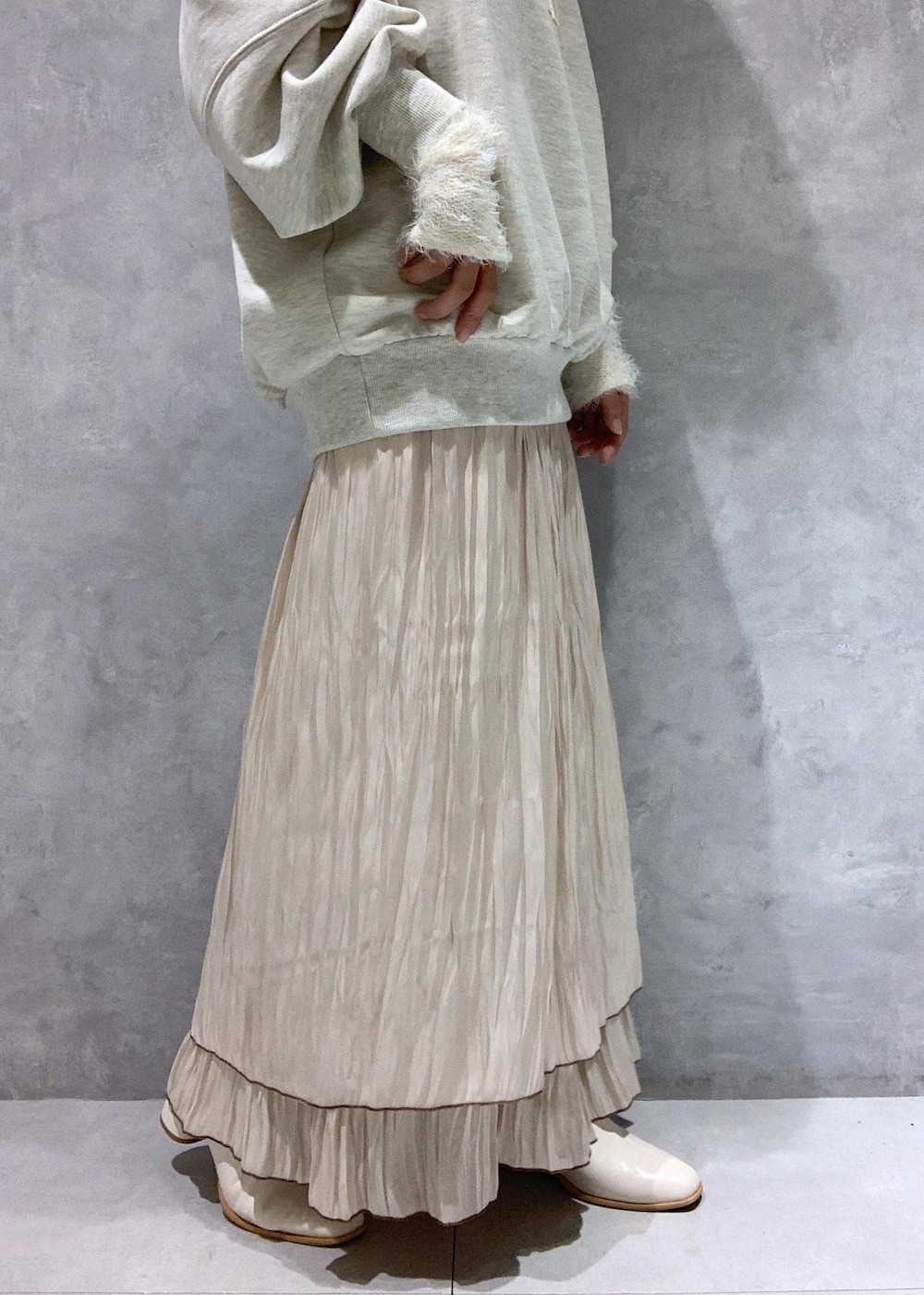 ホワイト系のブーツ、ベージュ系のスカート、ホワイト系のニット/セーターを着用したレディースの秋コーディネートの8枚目の写真