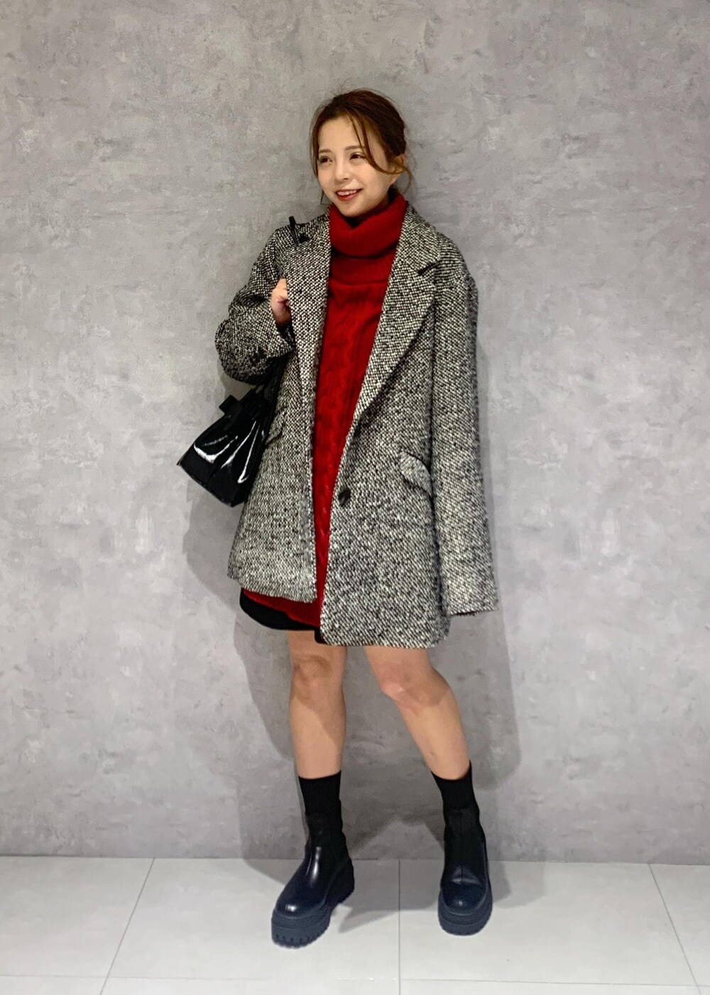 ブラック系のショルダーバッグ、ブラック系のブーツ、レッド系のワンピースを着用したレディースの冬コーディネートの2枚目の写真