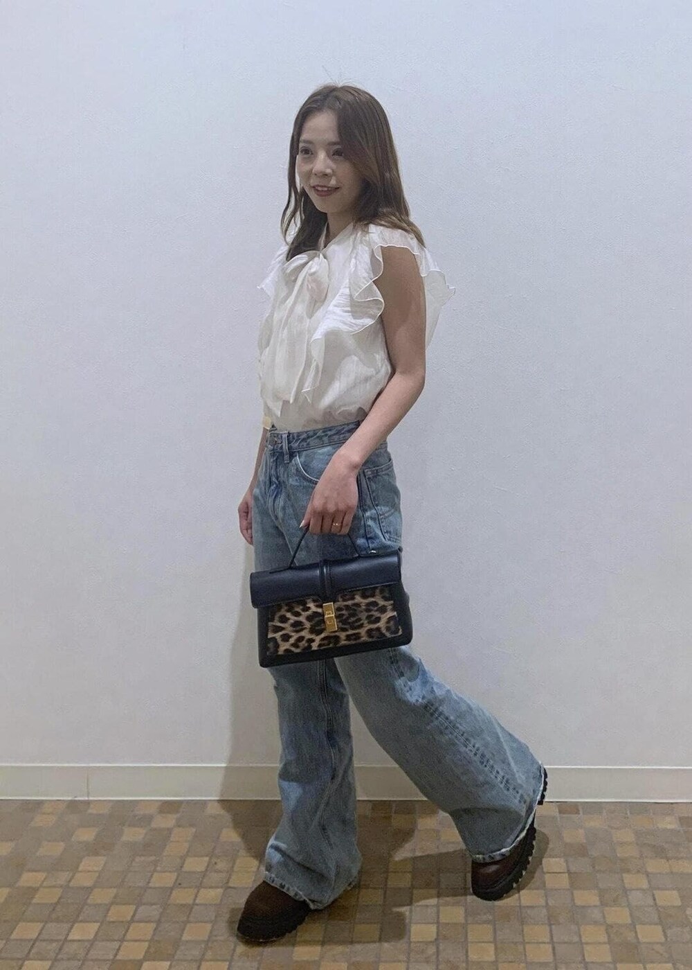 ホワイト系のシャツ/ブラウス、ブラウン系のブーツ、ブルー系のデニムパンツを着用したレディースの夏コーディネートの2枚目の写真