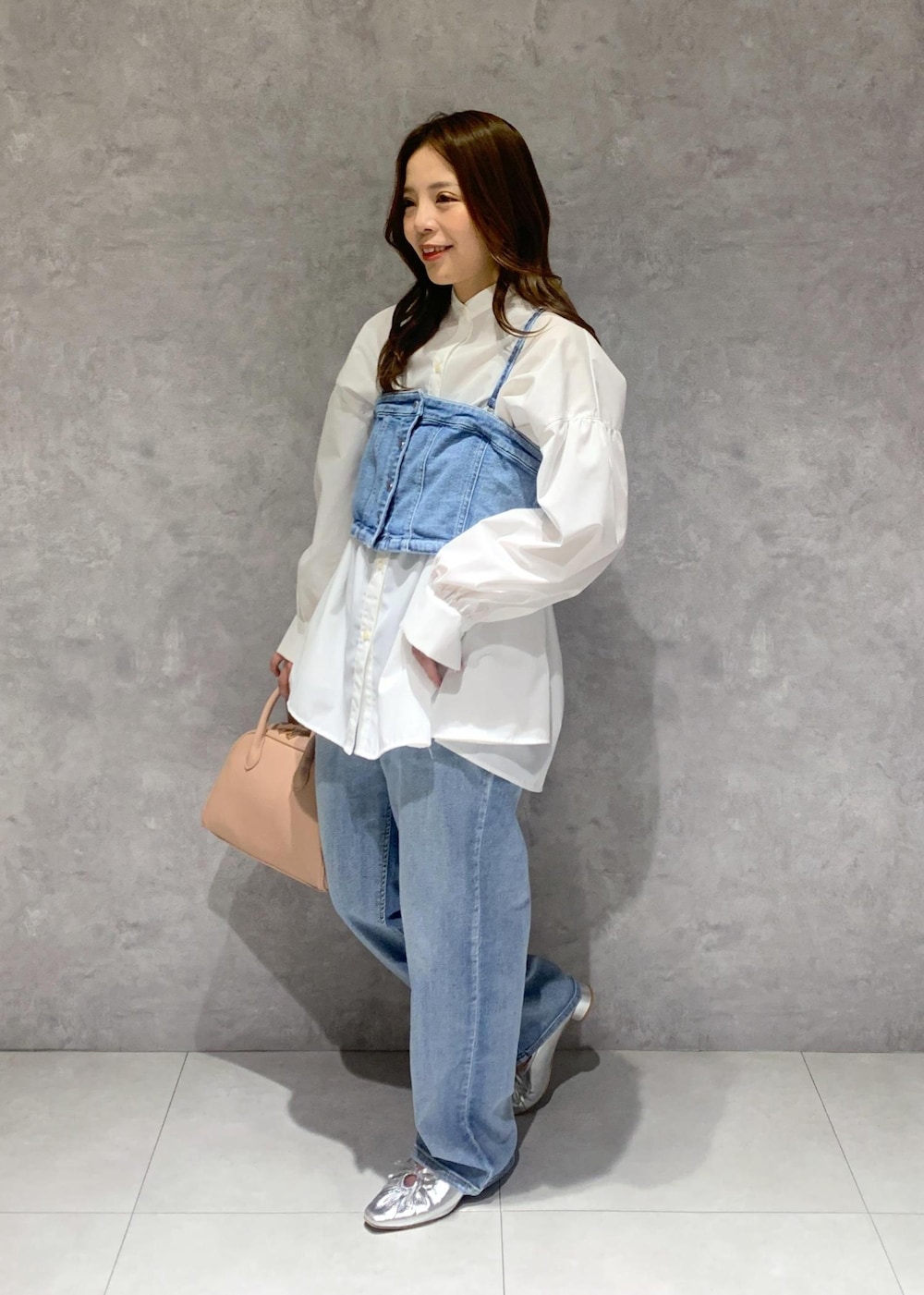 シルバー系のパンプス、ブルー系のベスト、ホワイト系のシャツ/ブラウスを着用したレディースの冬コーディネートの3枚目の写真