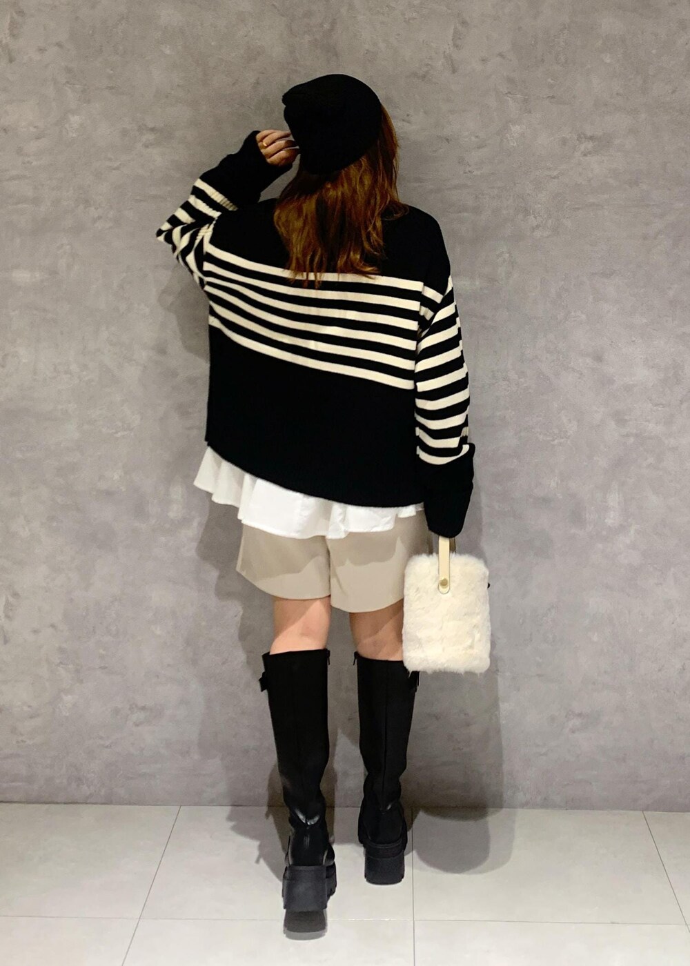 ブラック系のブーツ、ホワイト系のシャツ/ブラウス、ブラック系のニット/セーターを着用したレディースの秋コーディネートの5枚目の写真