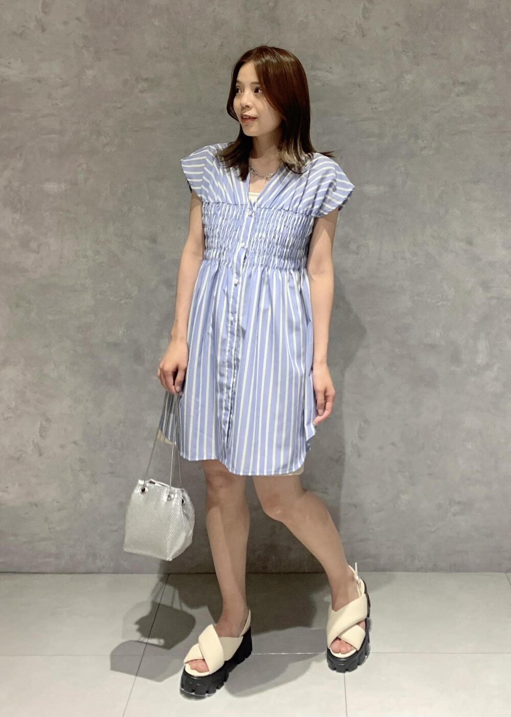 ホワイト系のサンダル、シルバー系のショルダーバッグ、ブルー系のシャツ/ブラウスを着用したレディースの夏コーディネートの2枚目の写真