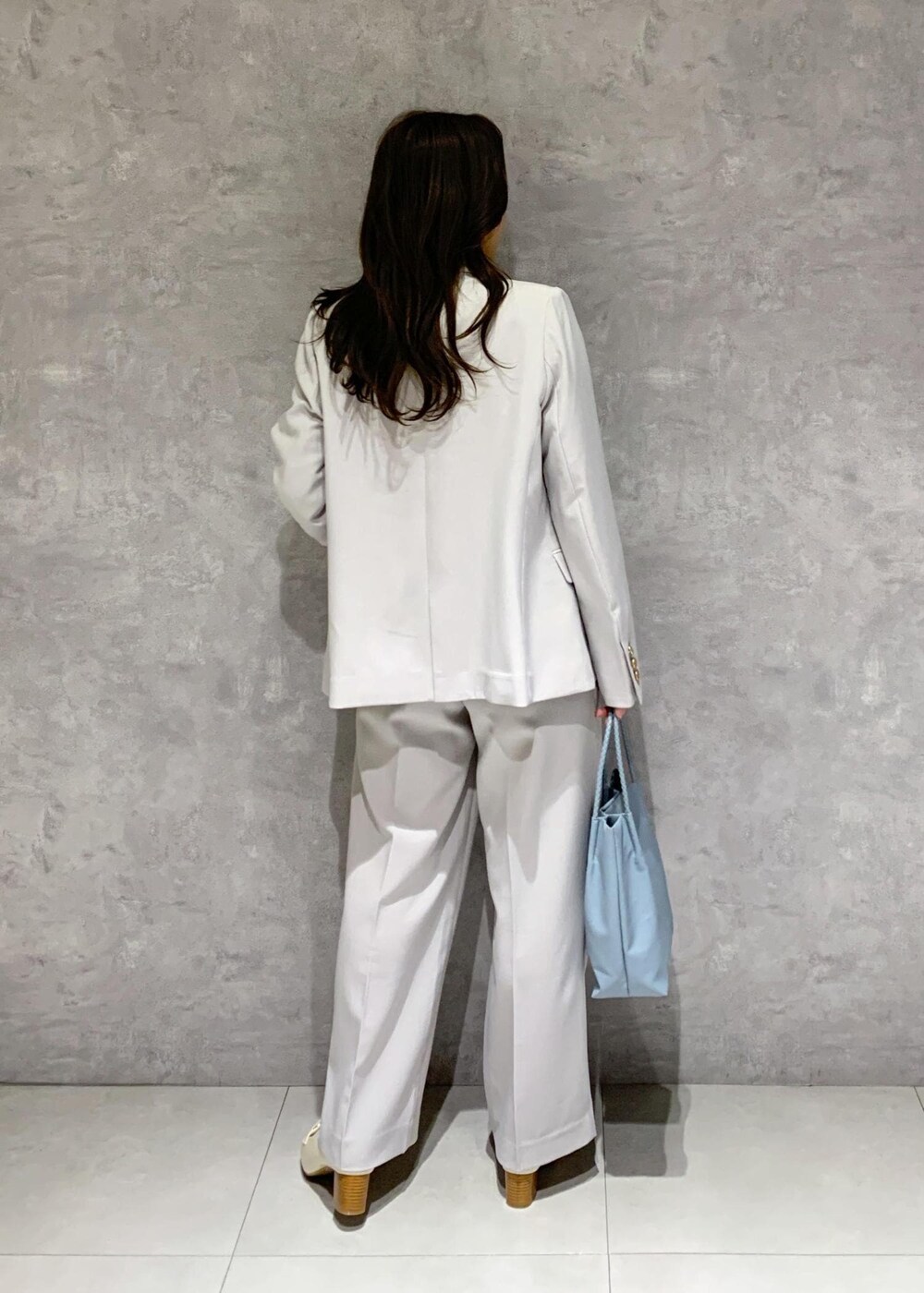 ブルー系のトートバッグ、ホワイト系のTシャツ/カットソー、ホワイト系のローファーを着用したレディースの冬コーディネートの5枚目の写真