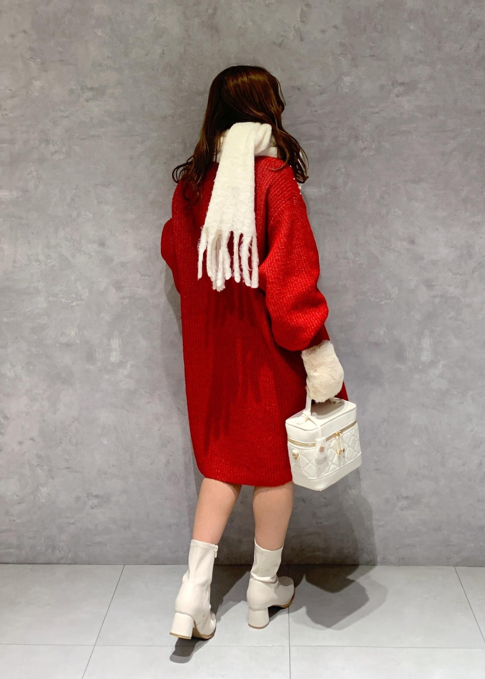 ホワイト系のブーツ、ホワイト系のハンドバッグ、レッド系のワンピースを着用したレディースの冬コーディネートの5枚目の写真