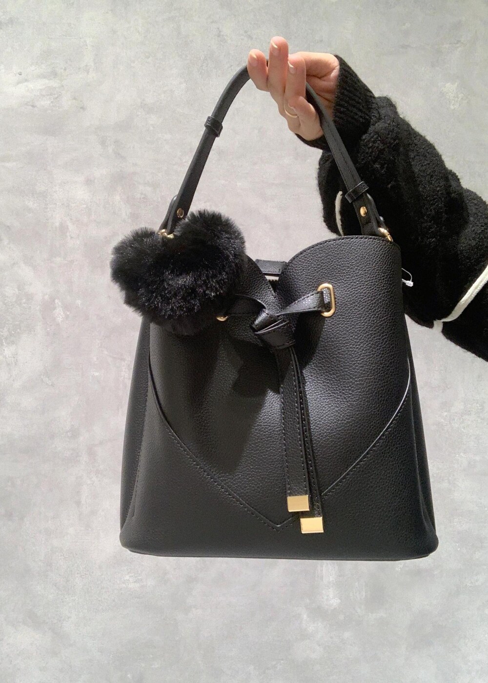 ブラック系のショルダーバッグ、ブラック系のブーツ、ブラック系のニット/セーターを着用したレディースの冬コーディネートの10枚目の写真