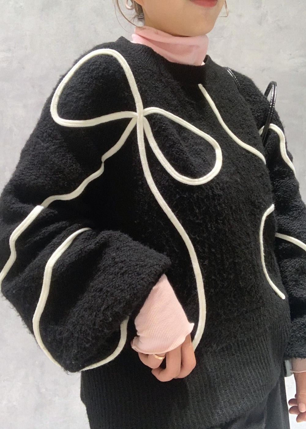 ブラック系のショルダーバッグ、ブラック系のブーツ、ブラック系のニット/セーターを着用したレディースの冬コーディネートの8枚目の写真