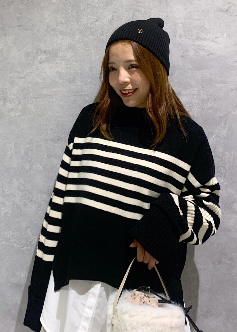 ブラック系のブーツ、ホワイト系のシャツ/ブラウス、ブラック系のニット/セーターを着用したレディースの秋コーディネートの6枚目の写真