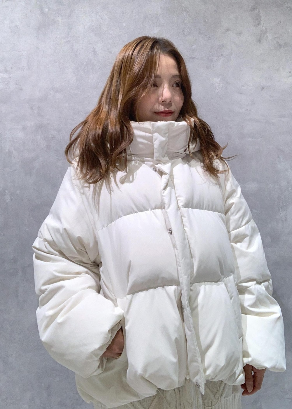 ホワイト系のブーツ、ホワイト系のワンピース、ホワイト系のダウンジャケット/コートを着用したレディースの秋コーディネートの6枚目の写真