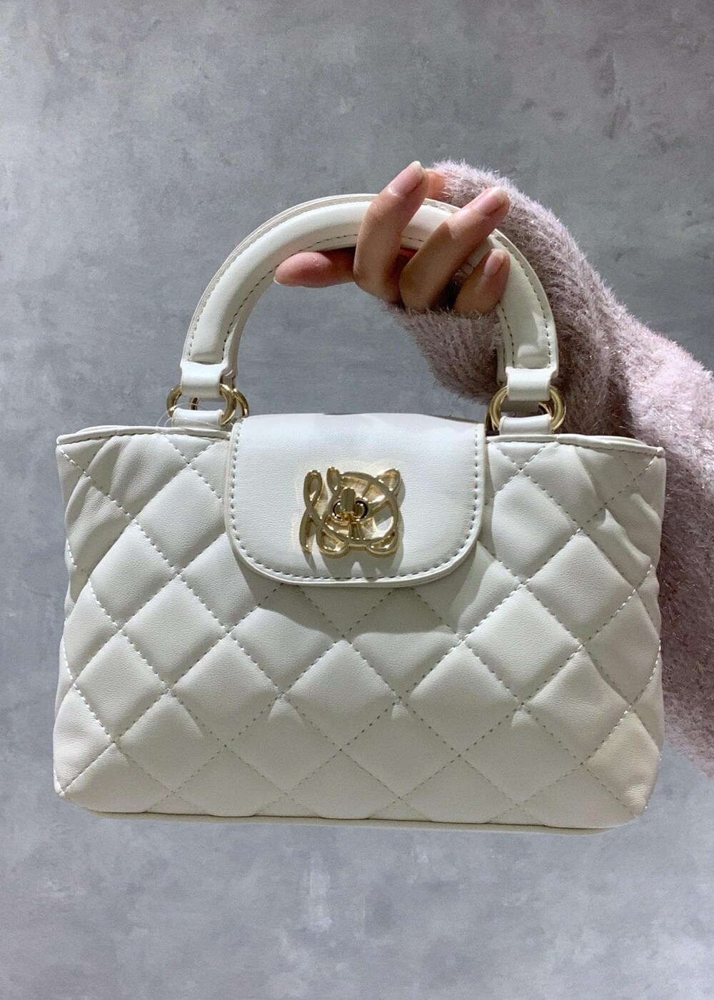 ピンク系のニット/セーター、ベージュ系のその他パンツ、ホワイト系のショルダーバッグを着用したレディースの冬コーディネートの10枚目の写真